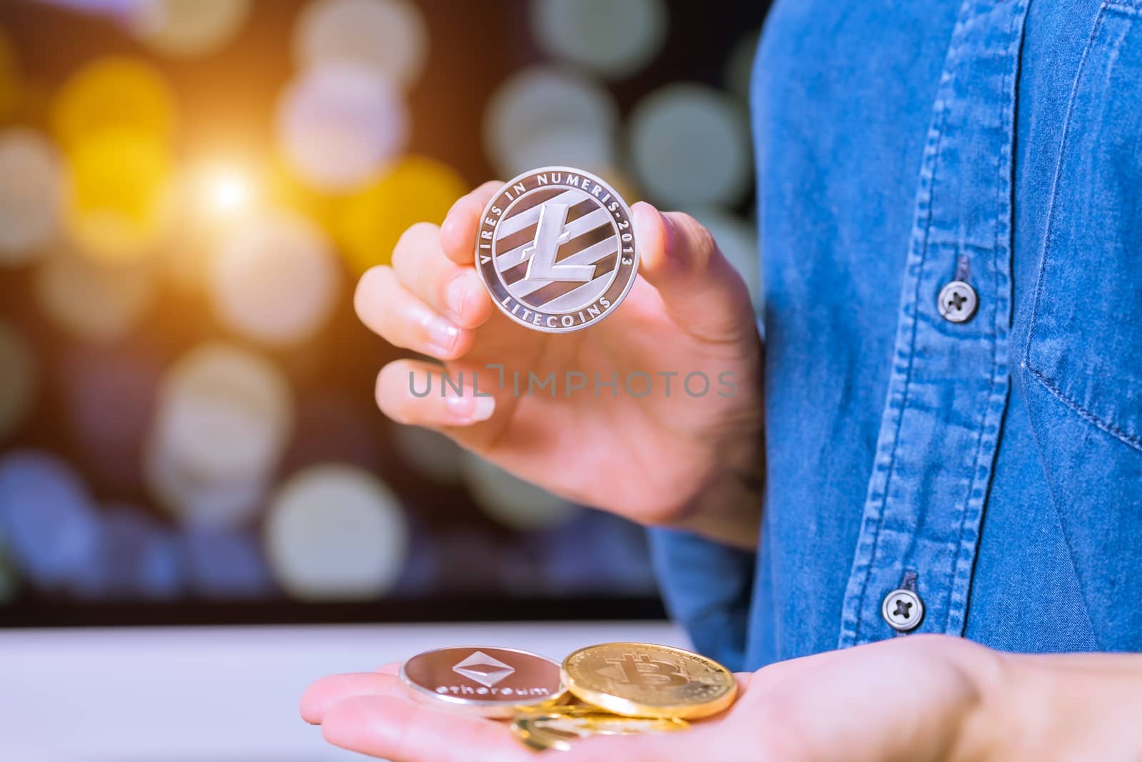 cryptocurrency coins - Litecoin, Ethereum, Bitcoin, Ripple. Women hold the cryptocurrency coin on hand. Physical bitcoins gold and silver coins
