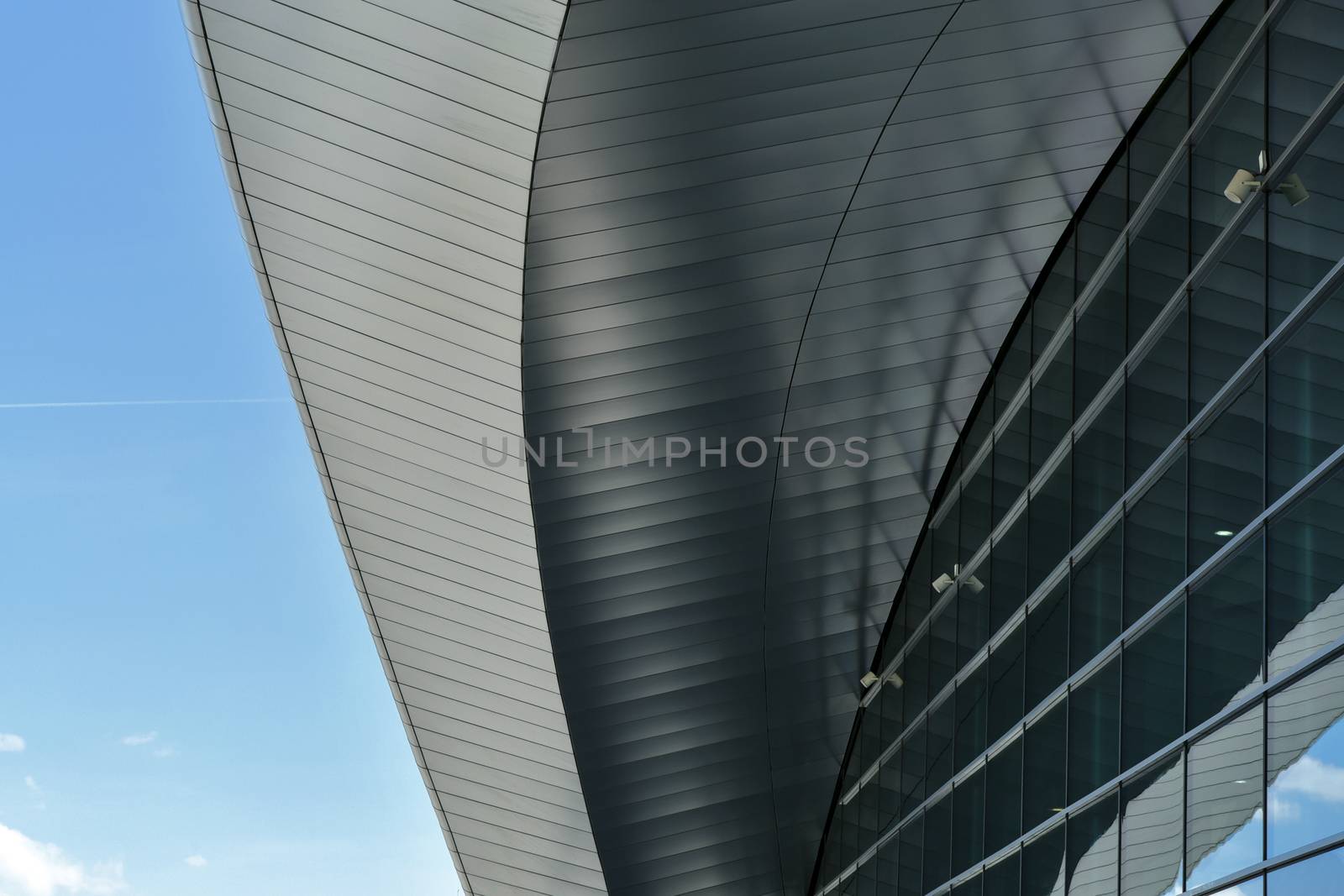 Metal glass part of the building against the blue sky as an abstract industrial background.