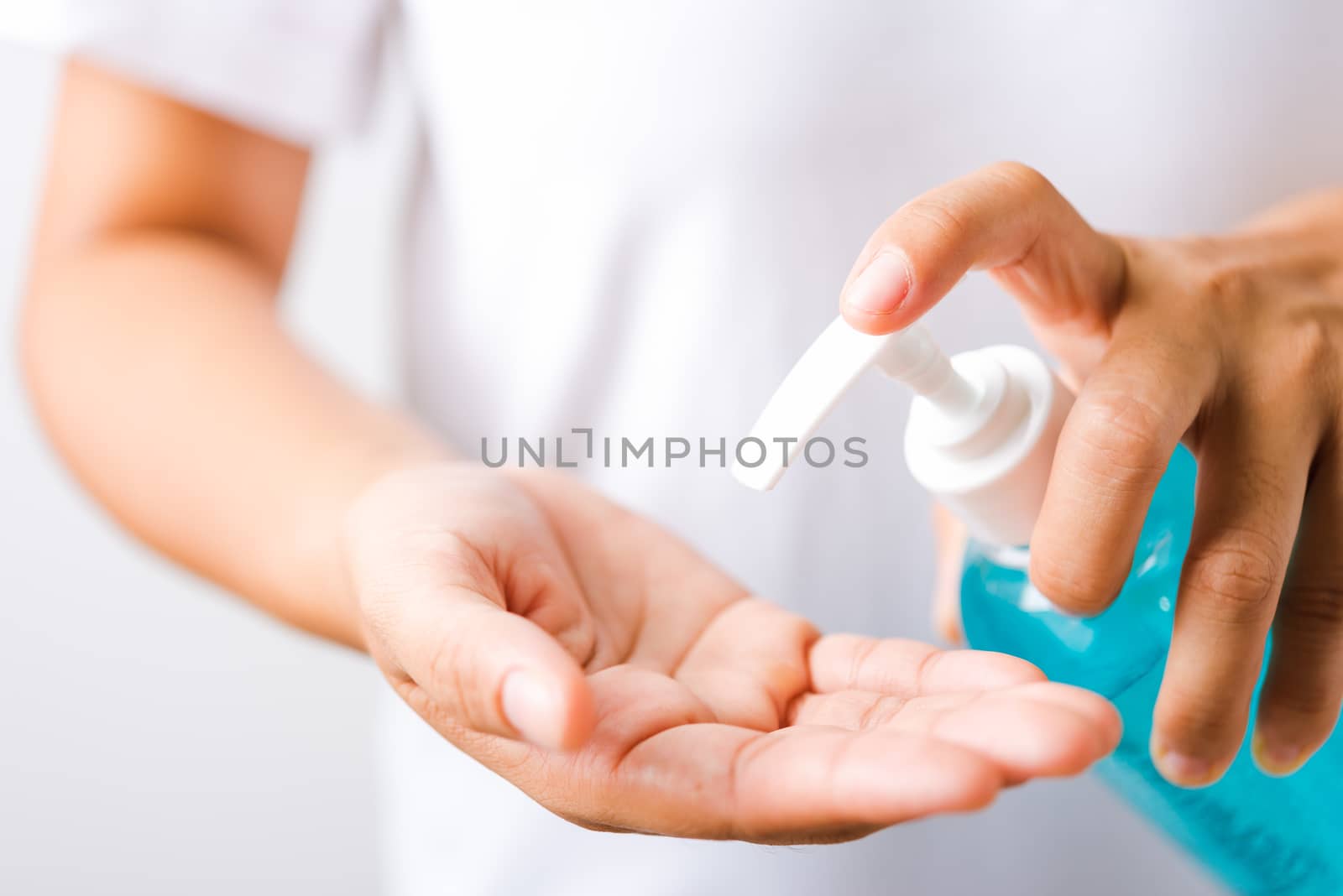 woman applying pump dispenser sanitizer alcohol gel by Sorapop
