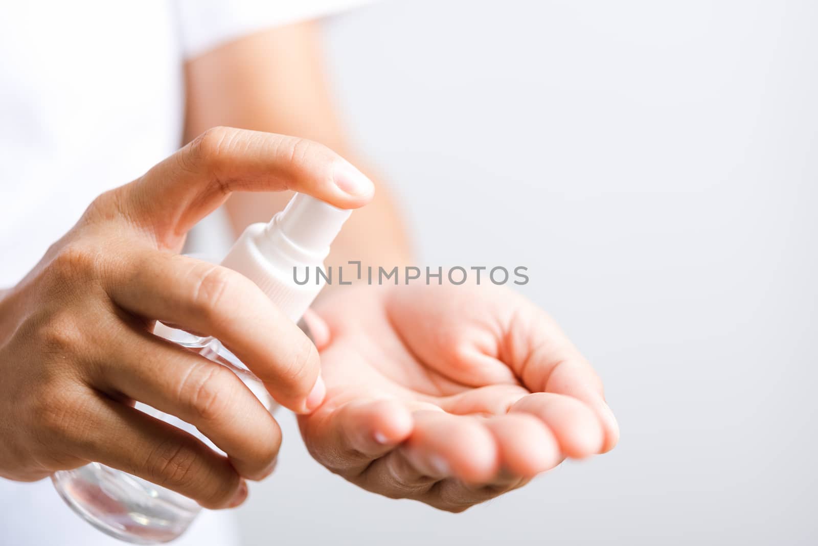 Closeup Hand Asian young woman applying spray pump dispenser sanitizer alcohol on hand wash cleaning, hygiene prevention COVID-19 or coronavirus protection concept, isolated on white background