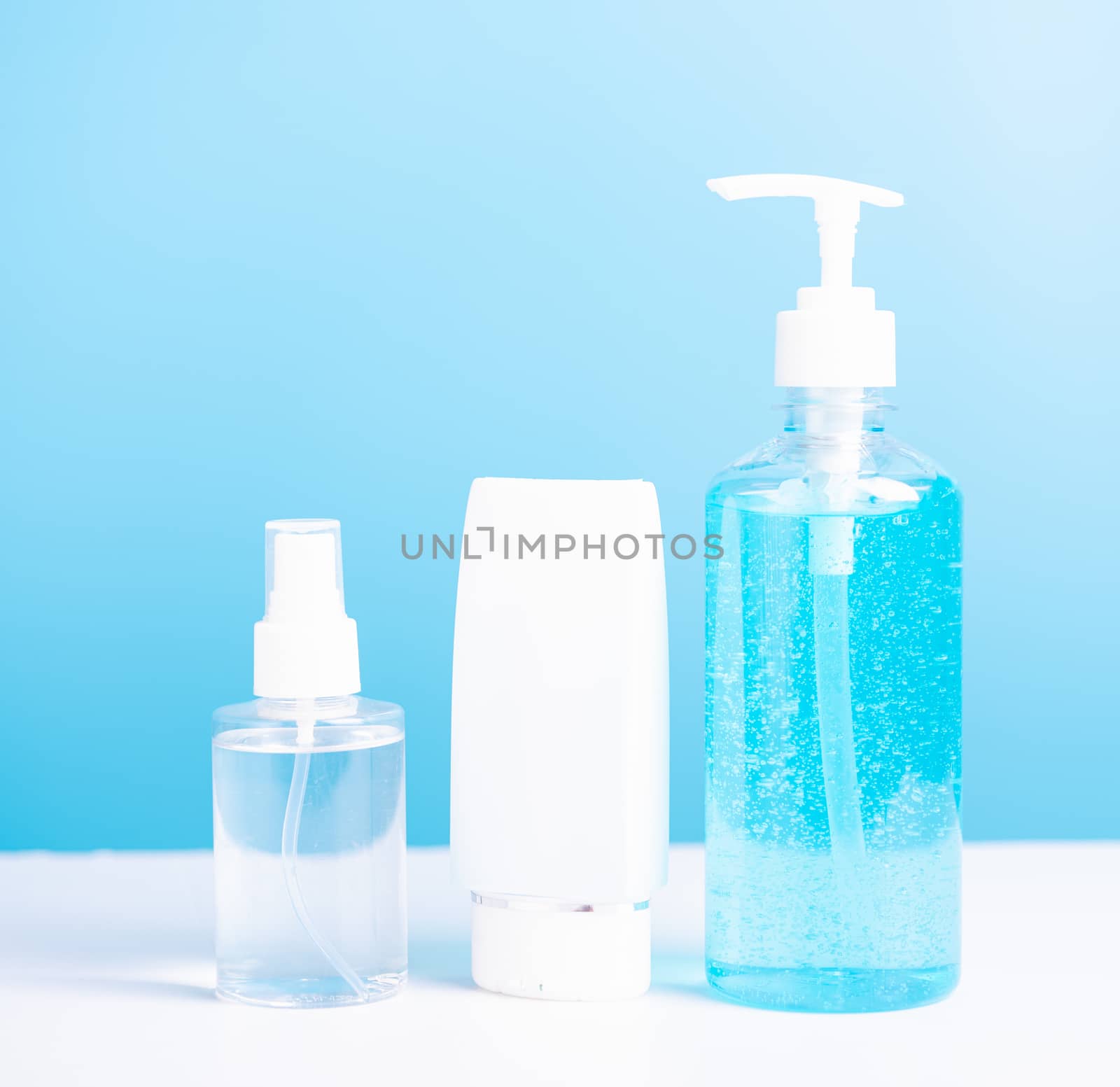 Plastic dispenser sanitizer alcohol gel pump and spray bottle for washing hand hygiene prevention of coronavirus virus studio shot on blue background