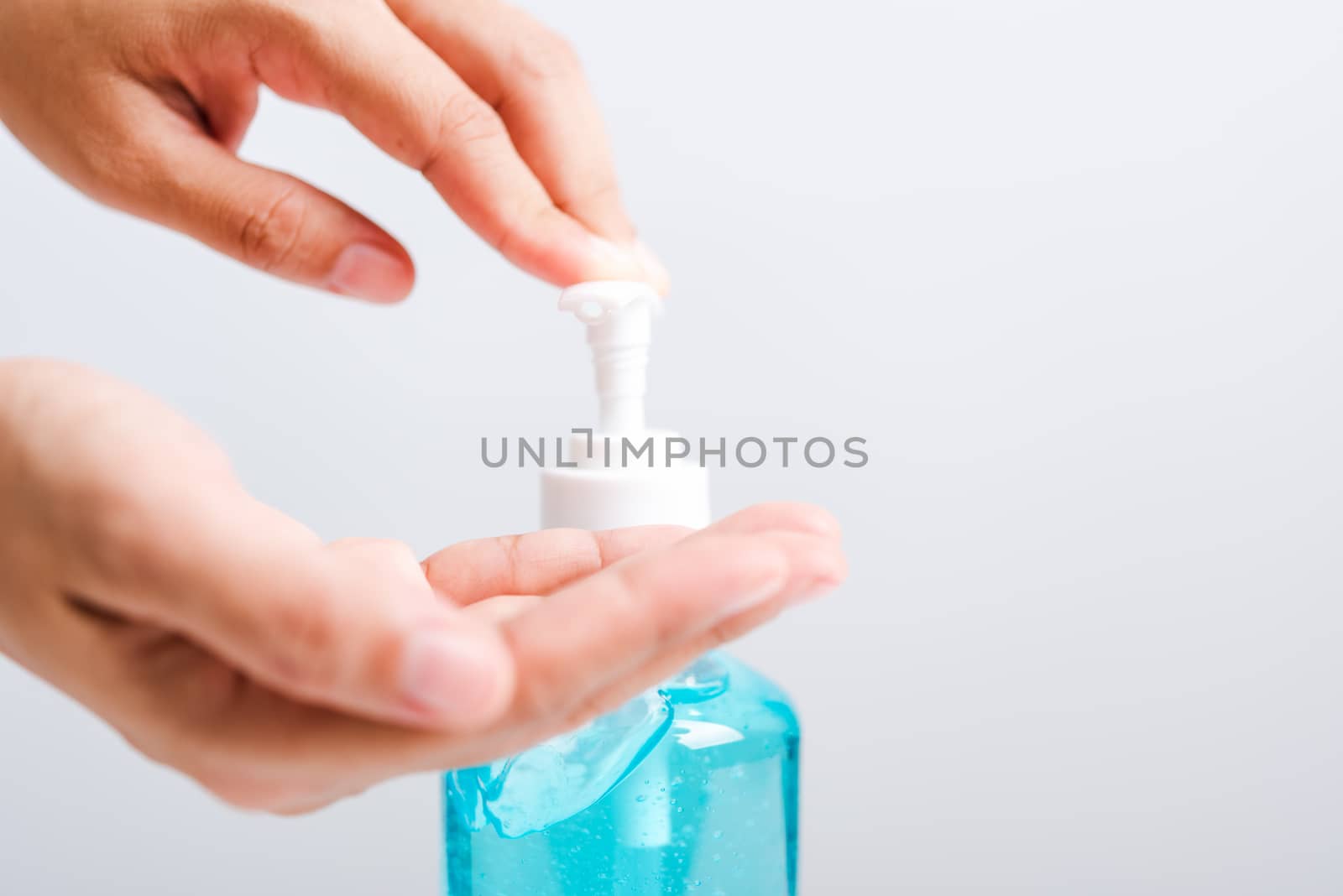 Close up Asian young woman applying press dispenser sanitizer alcohol gel pump to hand wash cleaning, hygiene prevention COVID-19 or coronavirus protection concept, isolated on white background
