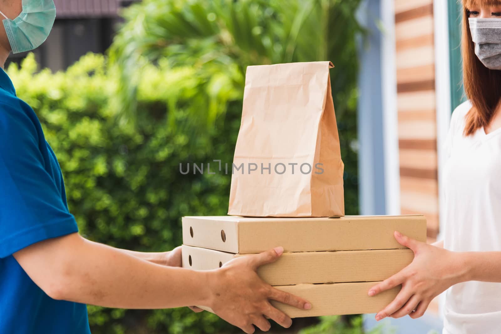 delivery express courier young man giving paper bags fast food a by Sorapop