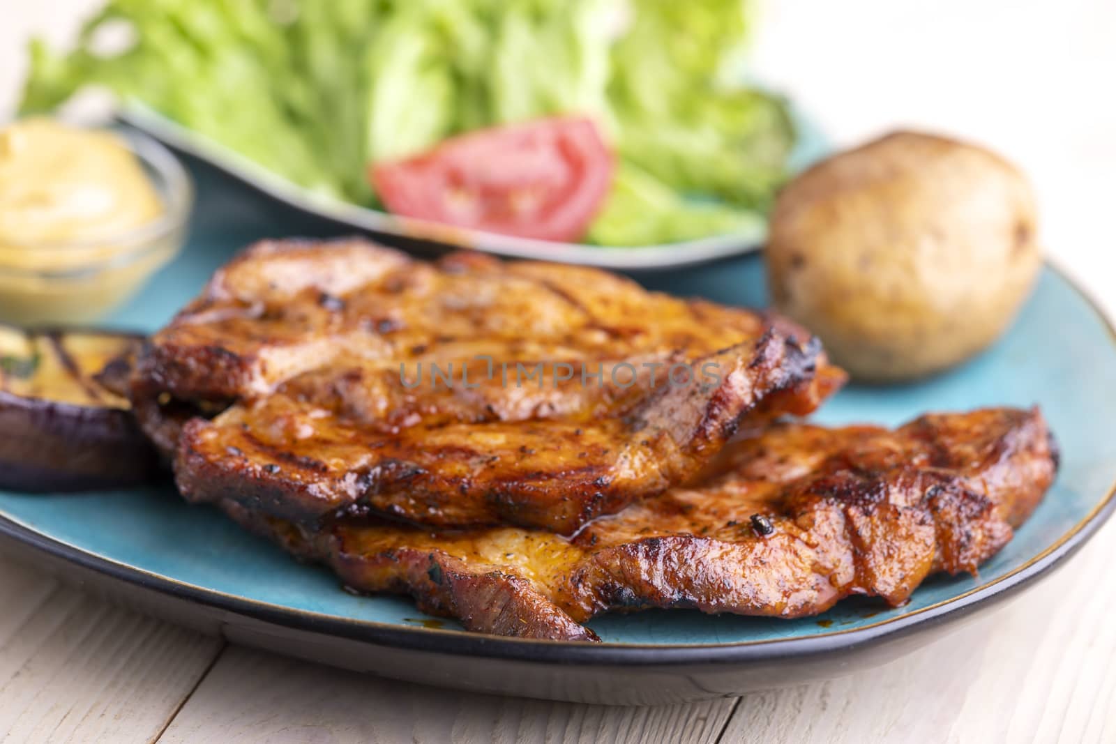 grilled pork steaks on a blue plate