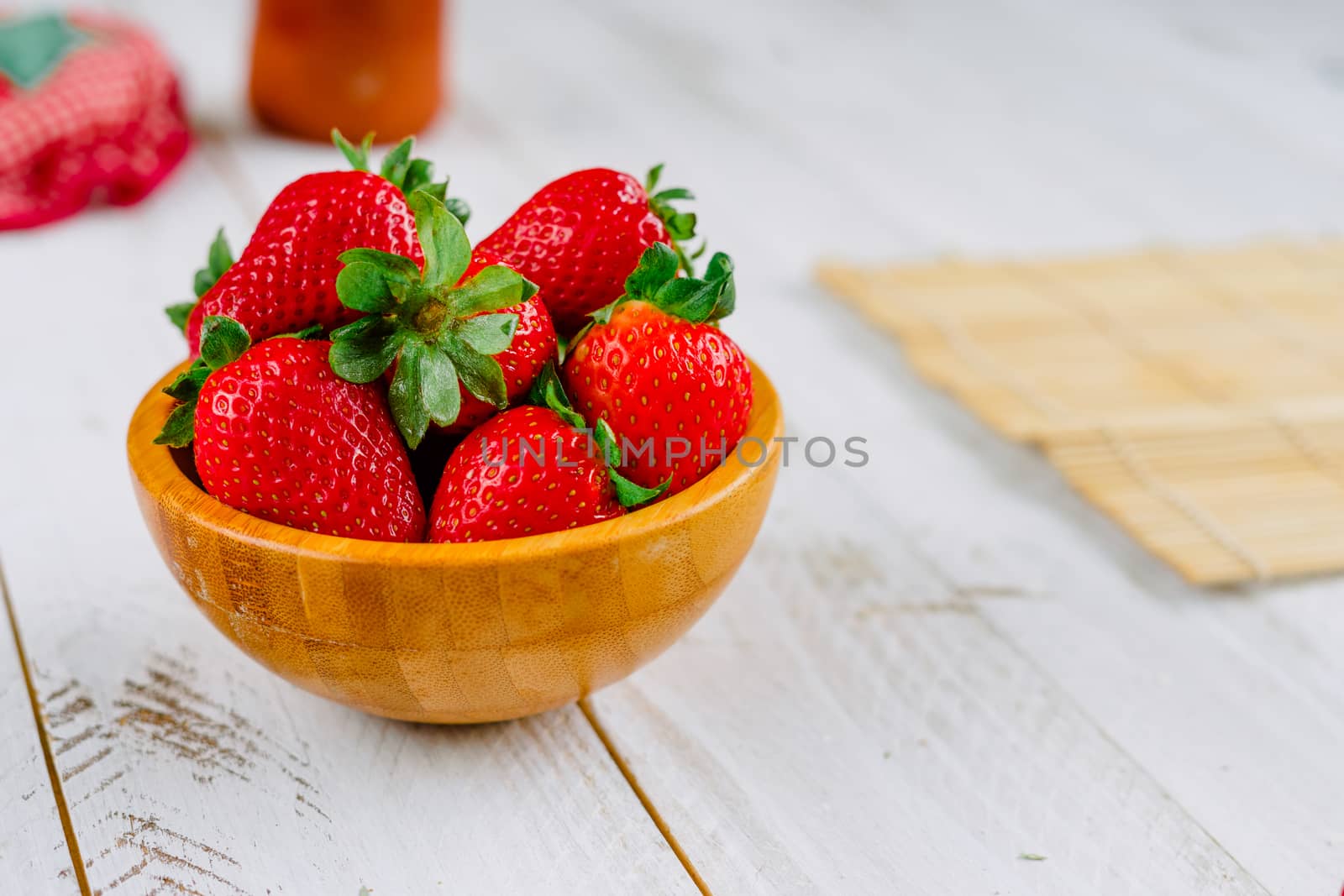 Organic strawberries on a bowl on a white wooden table much colorful