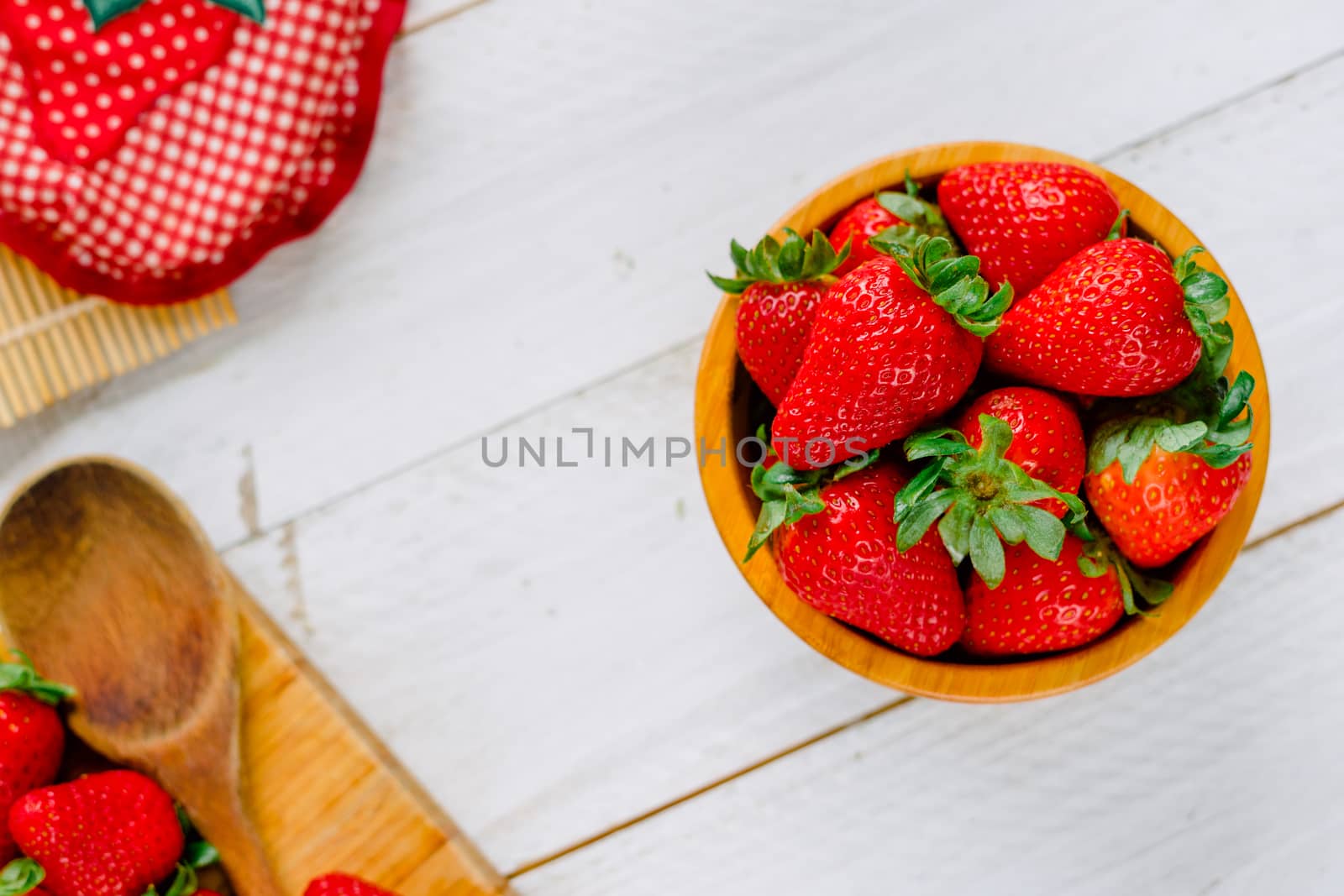 Organic strawberries on a bowl on a white wooden table much colorful