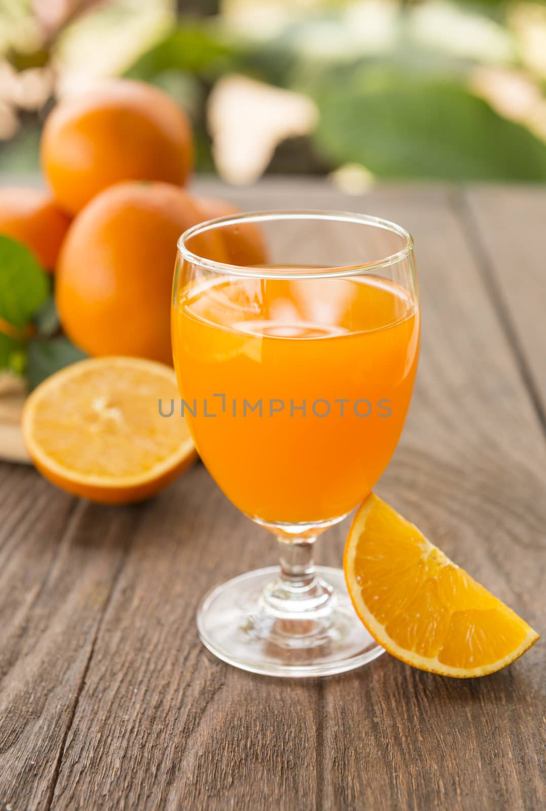 Orange juice is placed on a wooden table with natural light.-soft focus