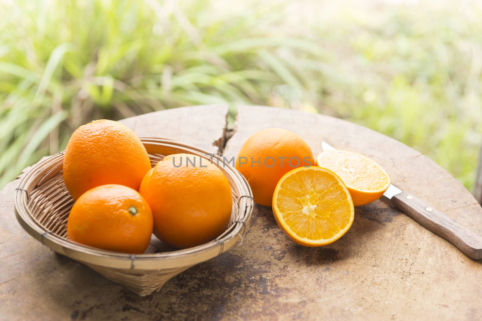 Woman cut orange on wooden table prepared to make orange juice.