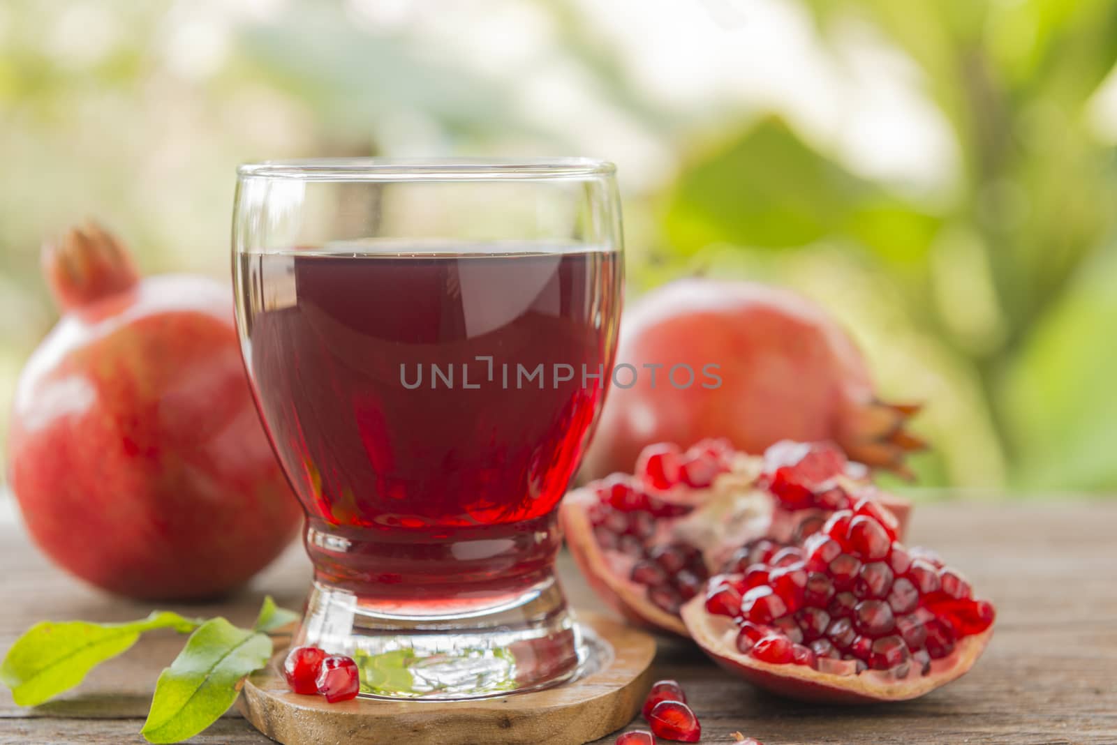 glass of pomegranate juice with fresh fruits on wooden table.