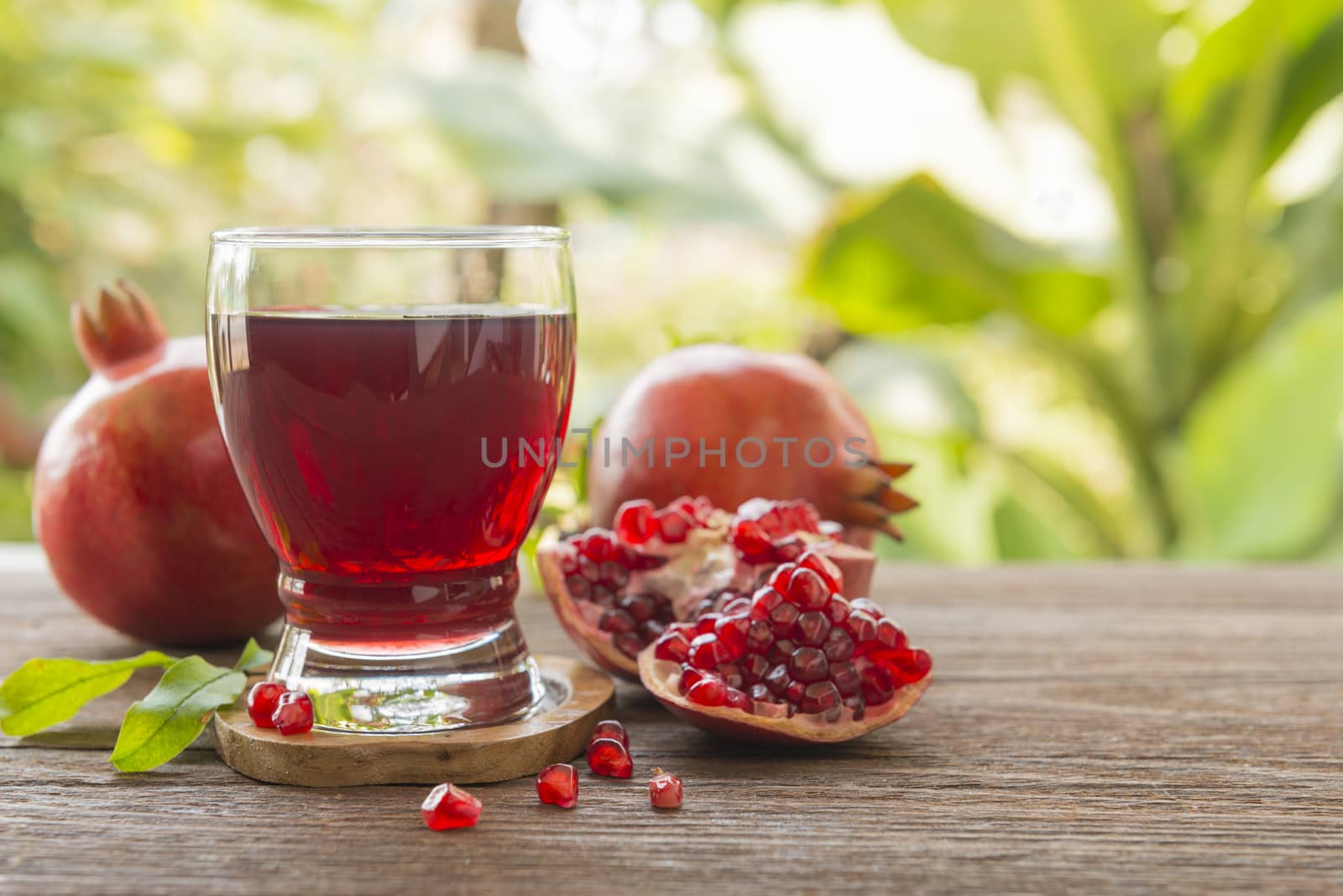 glass of pomegranate juice with fresh fruits on wooden table.