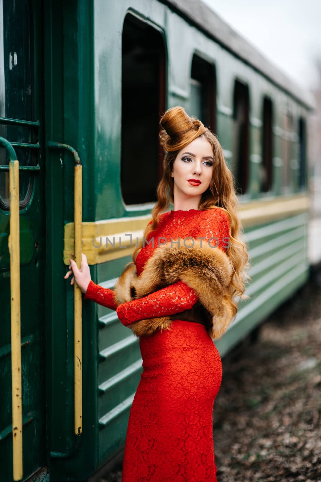 young girl with red hair in a bright red dress near an old passe by Andreua