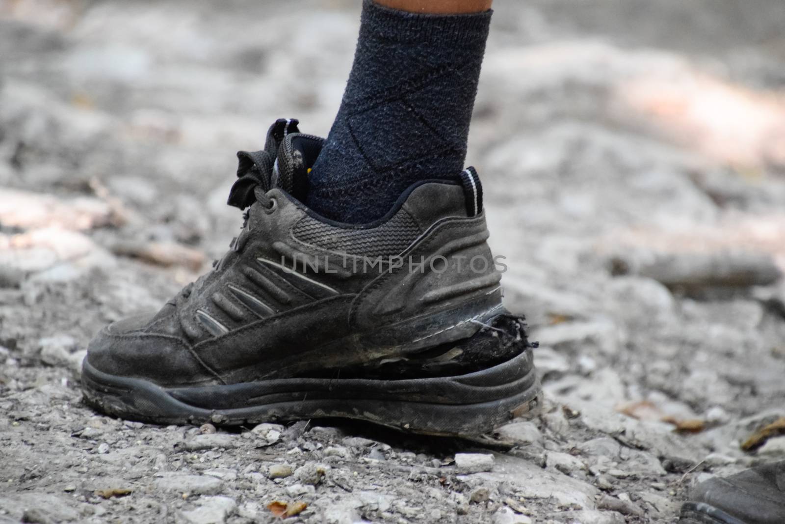 The detached sole on the tourist's sneakers. They broke their boots in the woods.