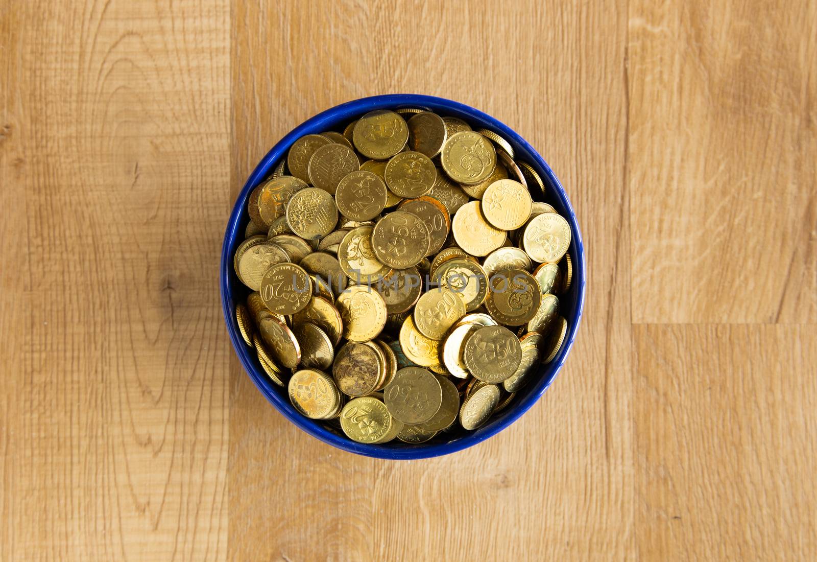 bowl of gold coin on wooden background
