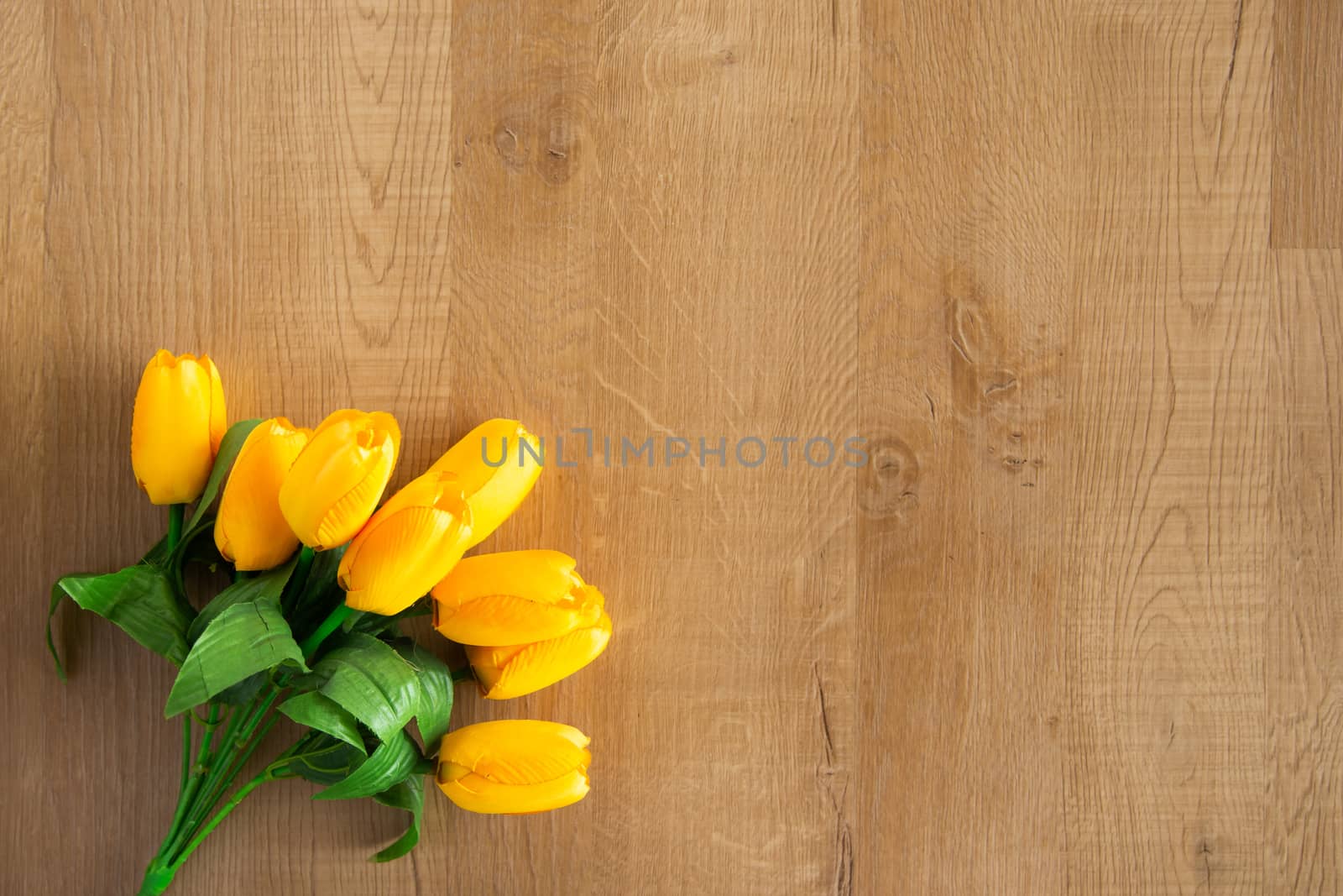 Tulips bunch on wooden background. Space for text.