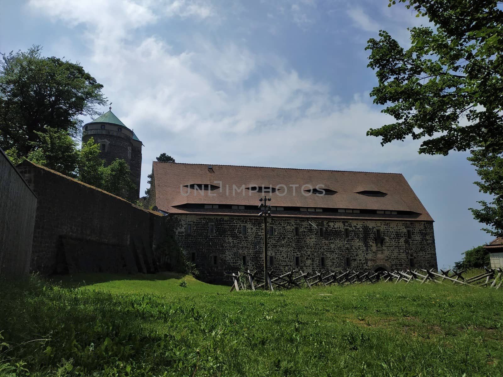 Park surrounding Stolpen castle with ancient wall and tower by pisces2386