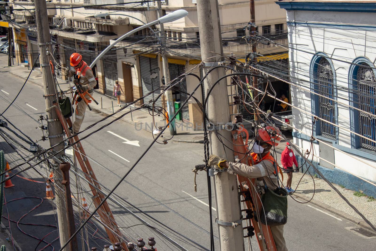 Men repairing electrical grid wires using masks because of COVID-19 by etcho