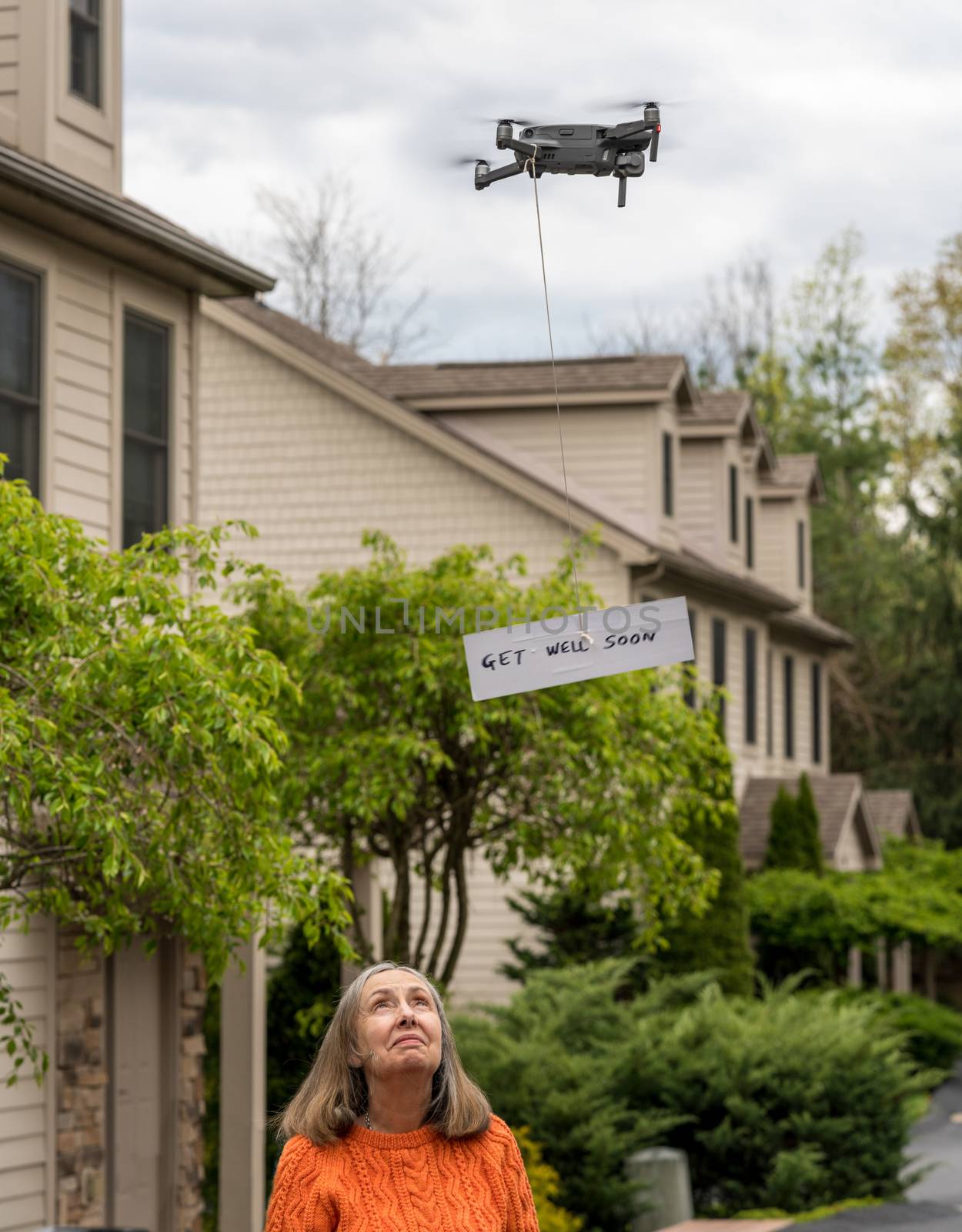 Drone delivering a get well soon message to isolated senior woman by steheap