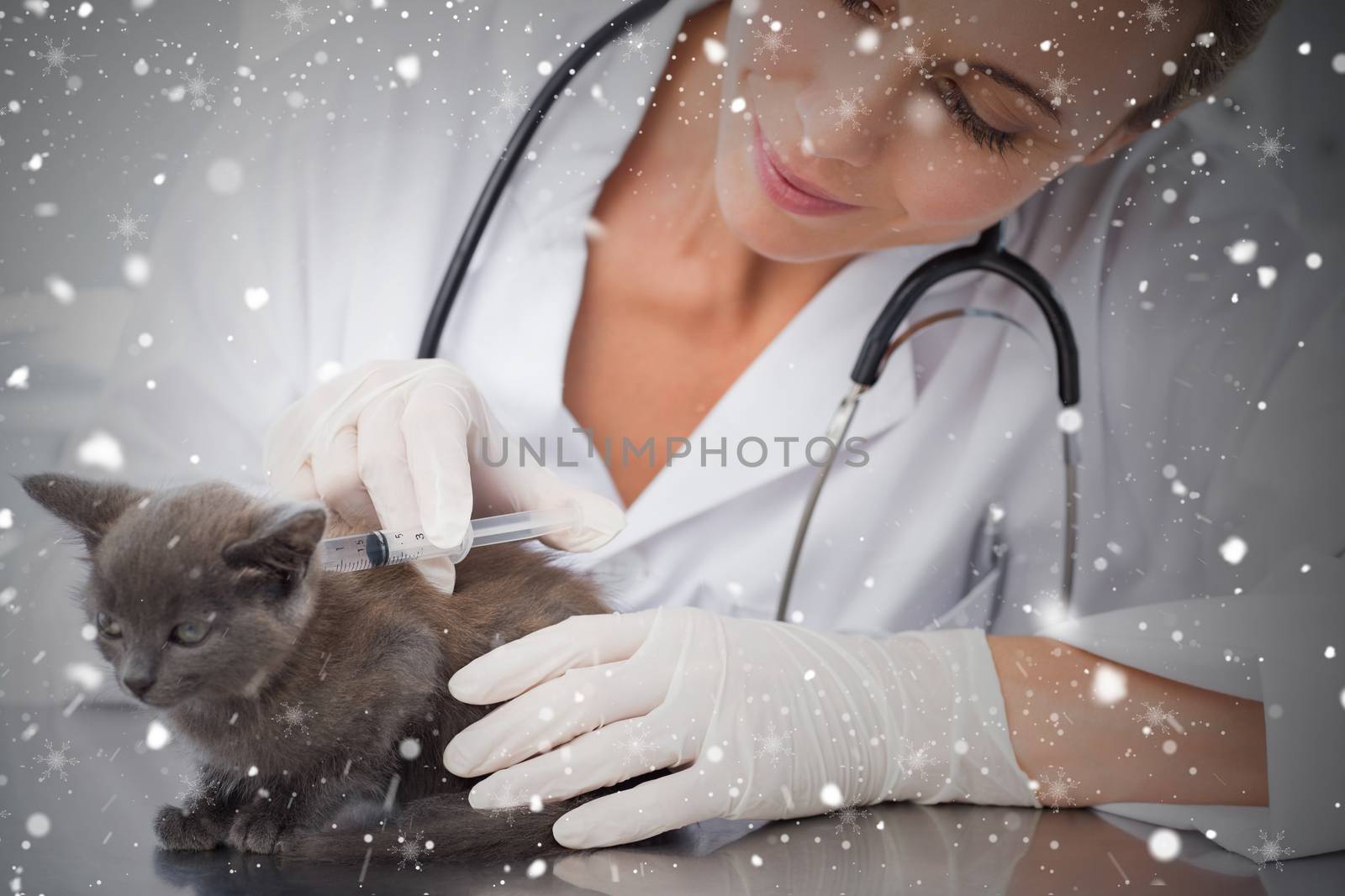 Composite image of female vet injecting a kitten against snow falling