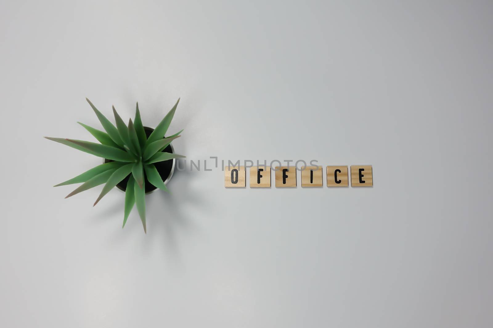The word Office written in wooden letter tiles on a white background.