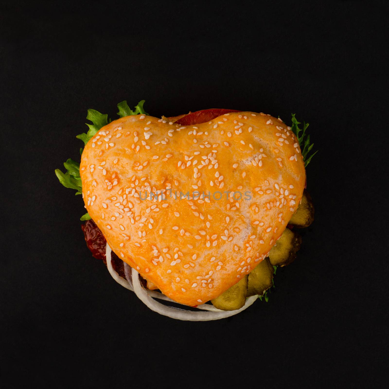 Heart shape hamburger on black by destillat