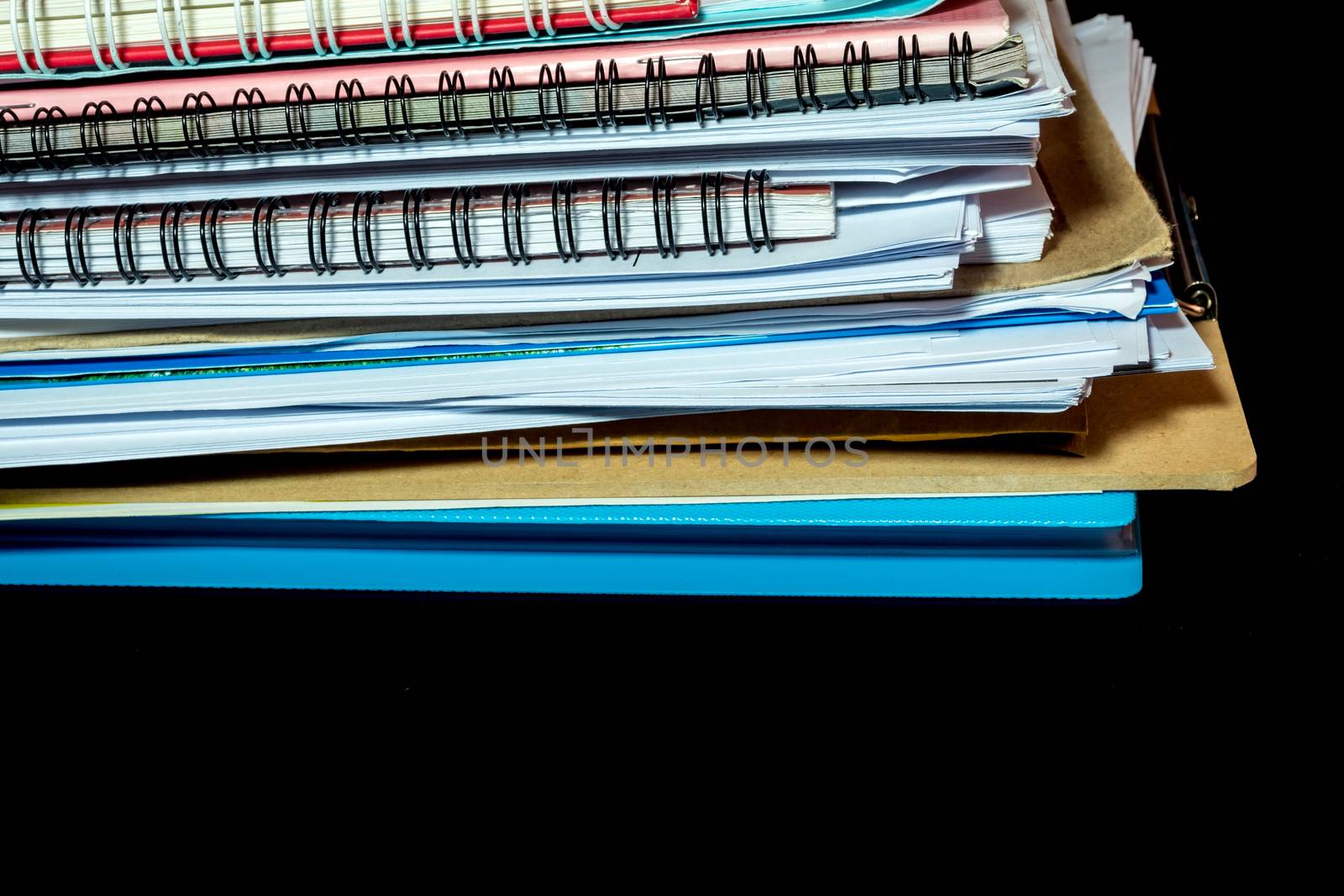 Stacked of office documents paper in the black background by Satakorn