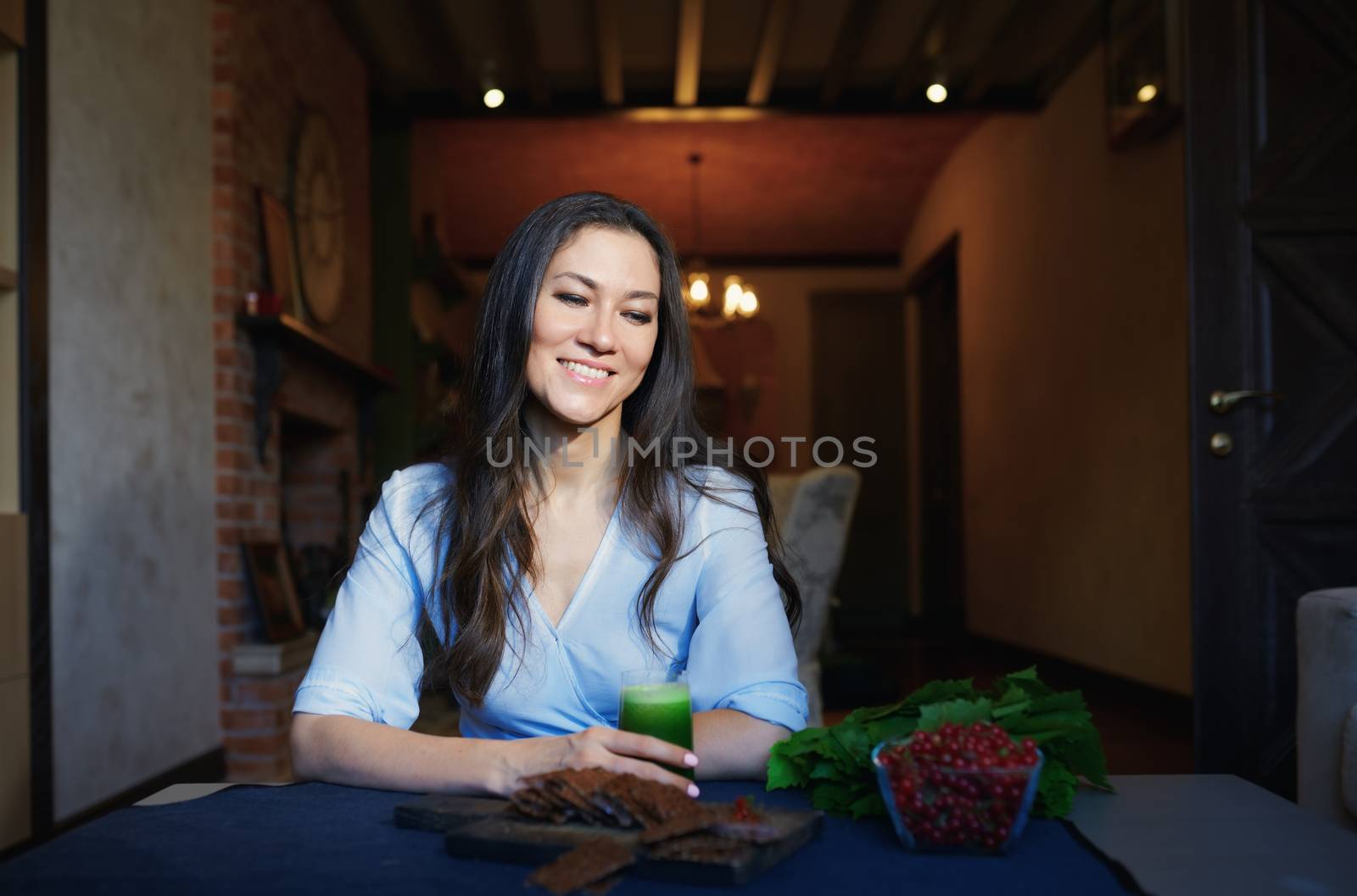 Smiling vegetarian woman sitting at the table with celery fresh  by Novic