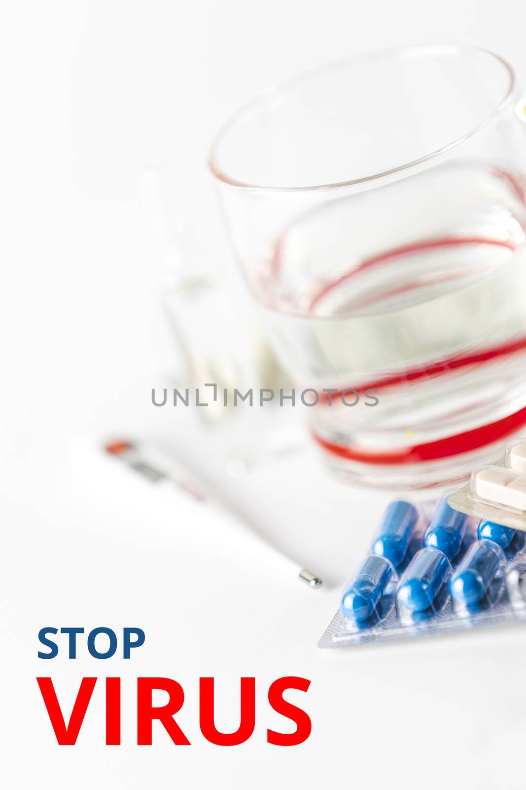 Medicine pills and capsules with glass of water on white background.   Stop Virus phrase. 2019 nCoV Coronavirus originating in Wuhan, China. Medical health concept.