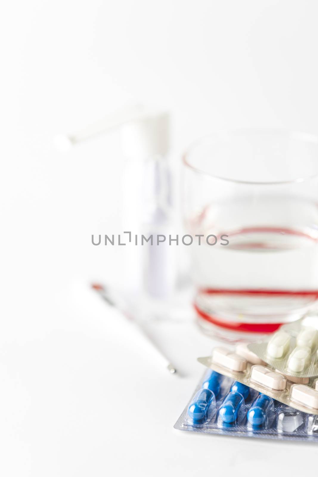 Medicine pills and capsules with glass of water on white background.   2019 nCoV Coronavirus originating in Wuhan, China. Medical health concept.