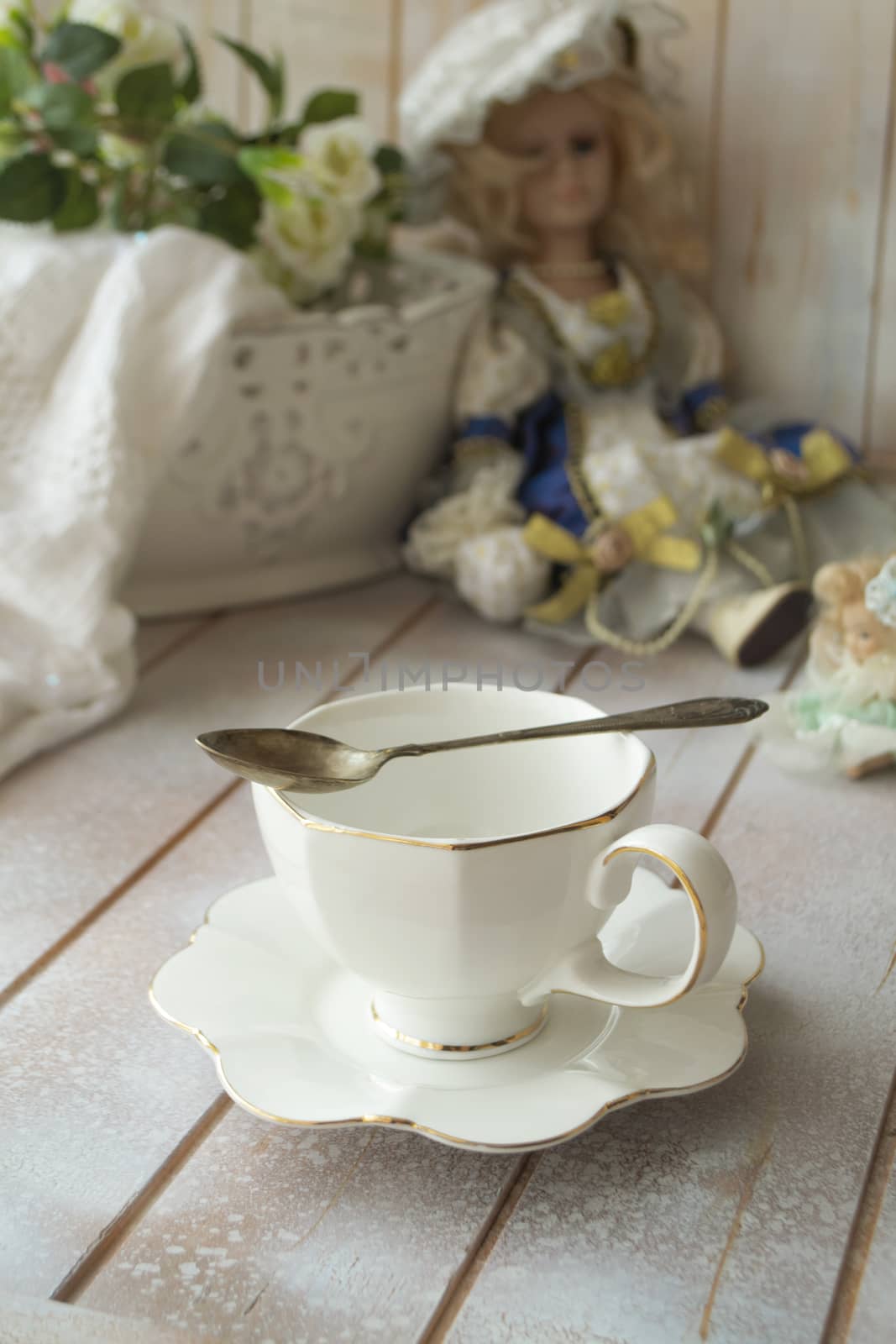 Elegant antique white tea cup on shabby table, vertical