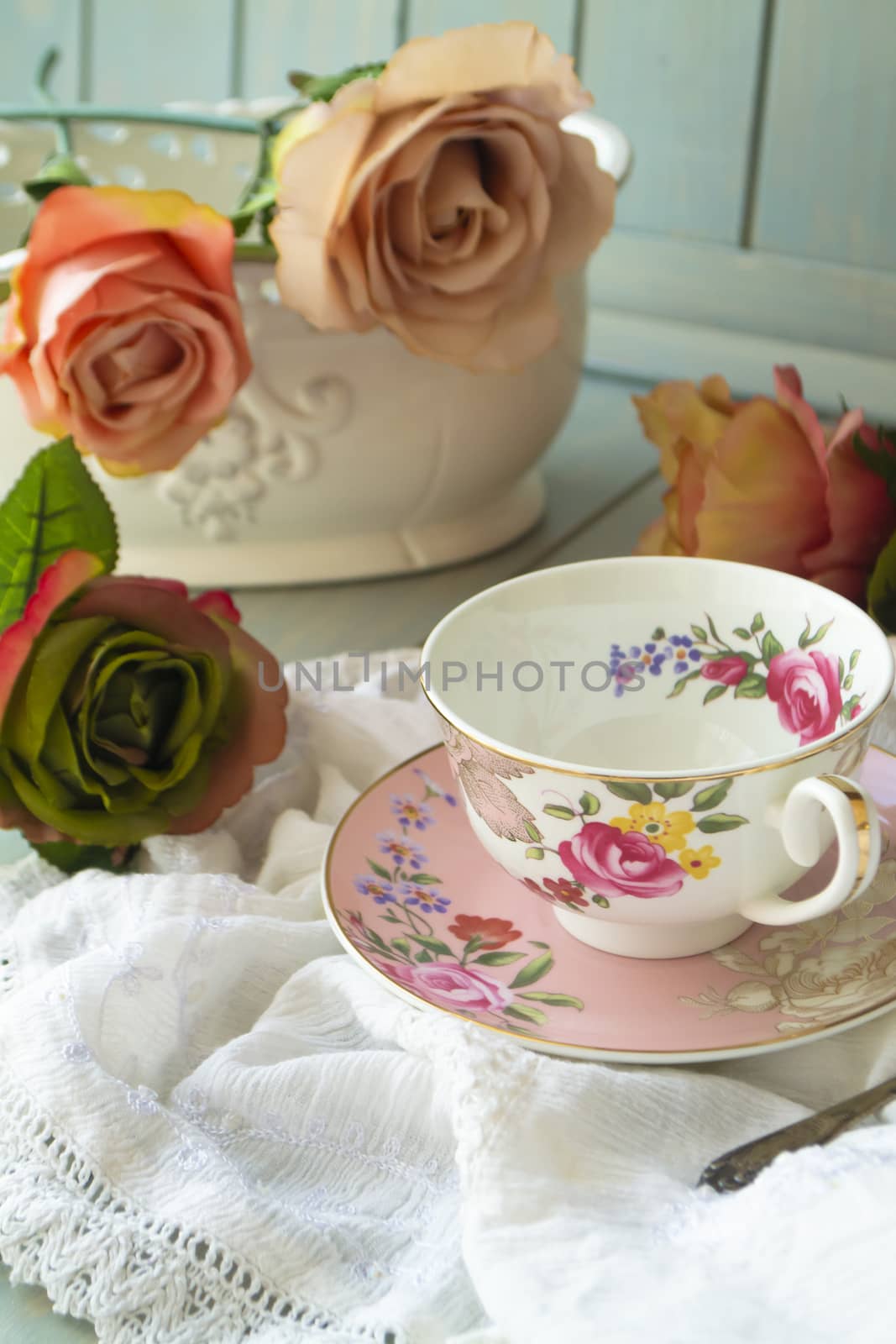Antique floral cup, saucer and vintage roses, vertical