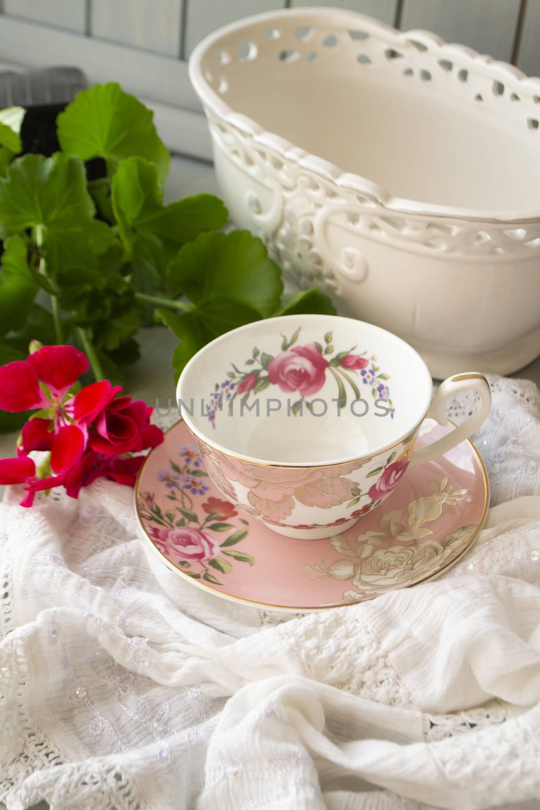Antique porcelain tea cup on lace table cover, vertical image