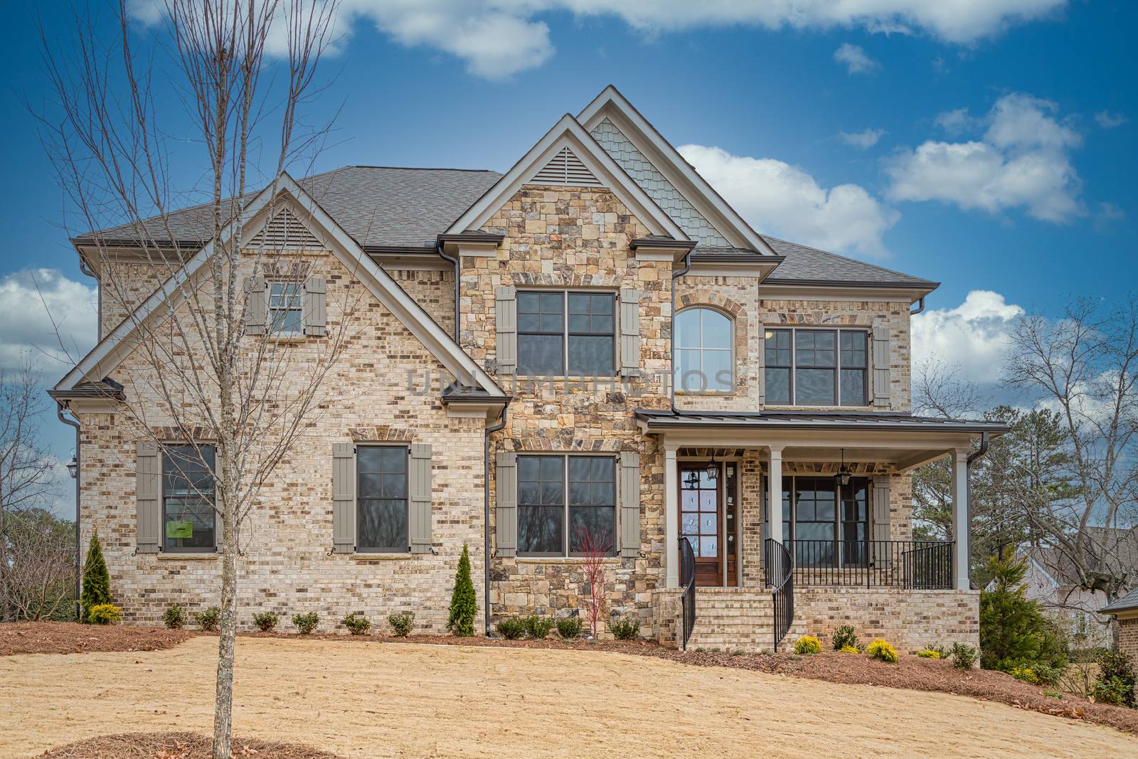 A new brick home on a landscaped hill in winter