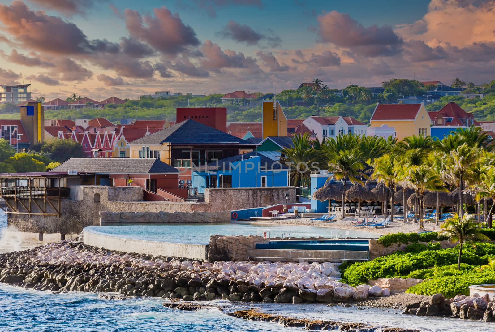 Colorful resort in Curacao with surf and palm trees