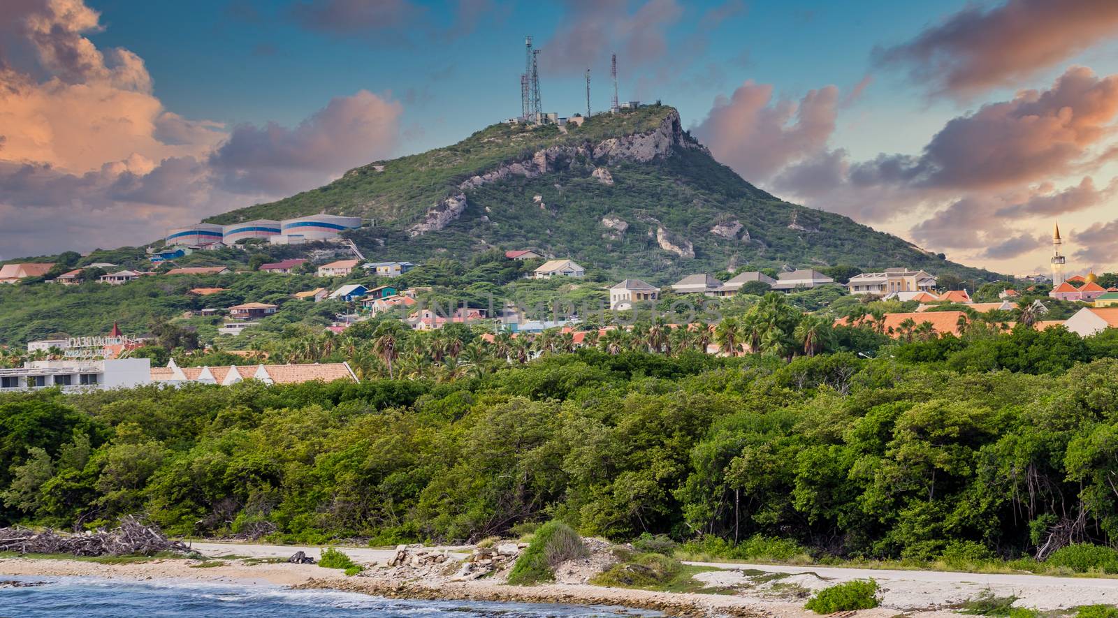 Colorful homes mixed with heavy industry on a green hill on Curacao