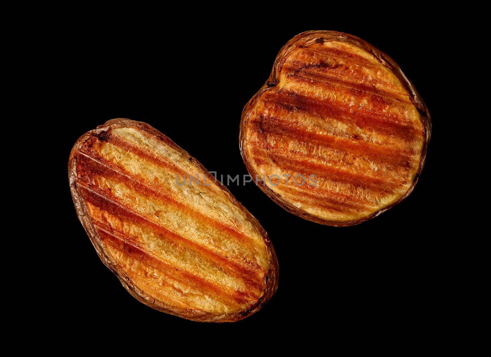 Two slices of grilled potatoes on a black background