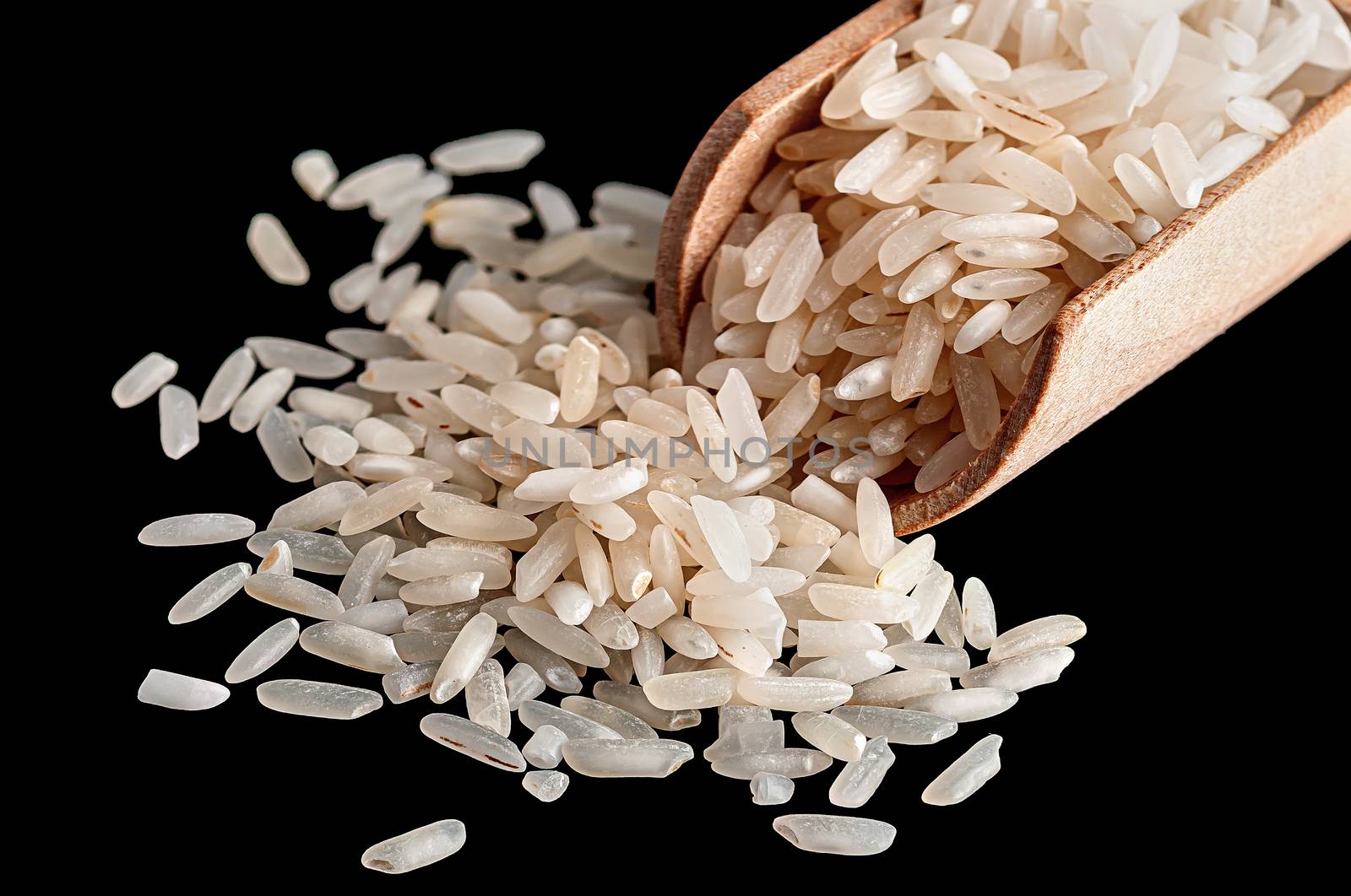 White rice in wooden scoop closeup on black background