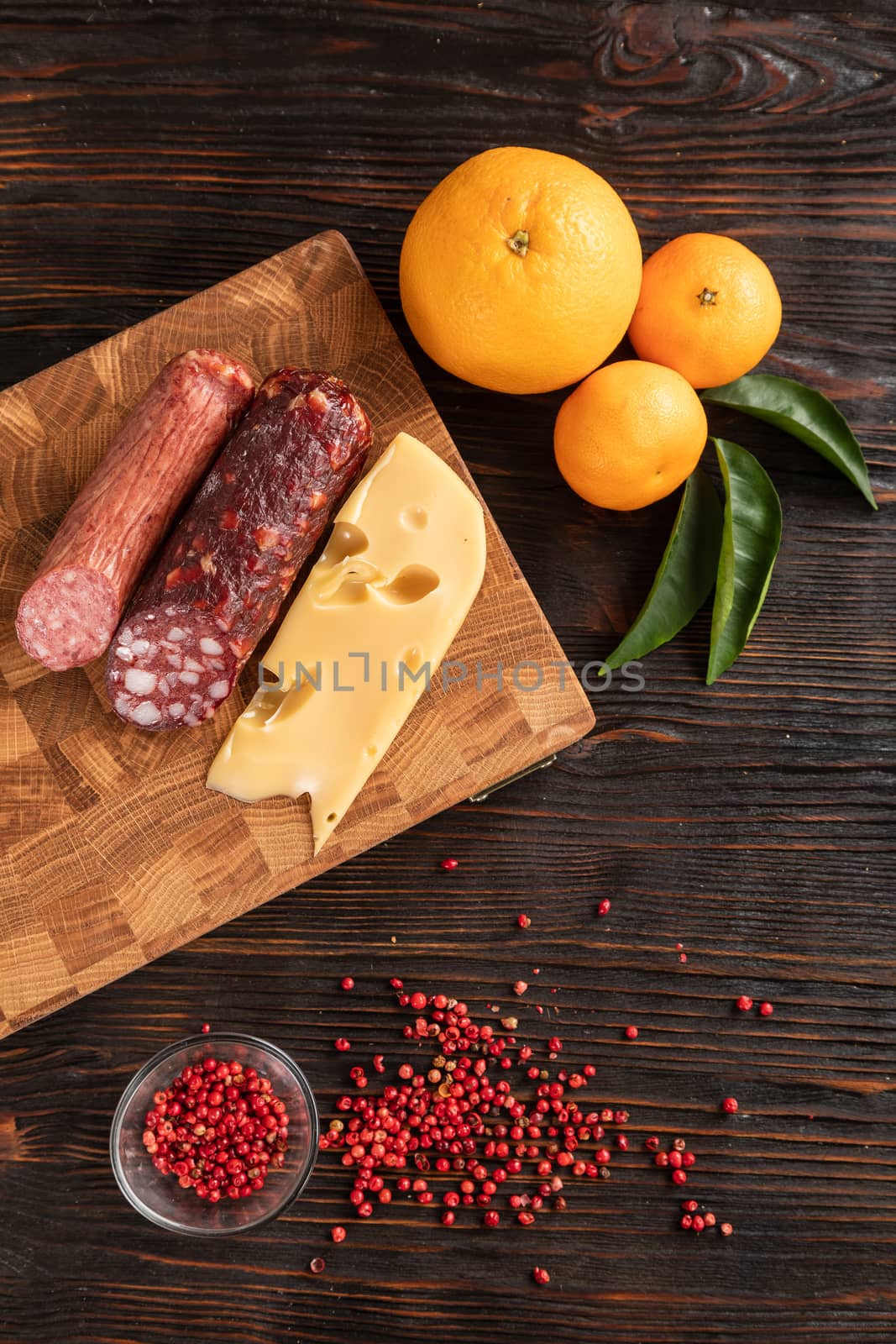 Sausage, cheese and fruit on cutting board by sveter