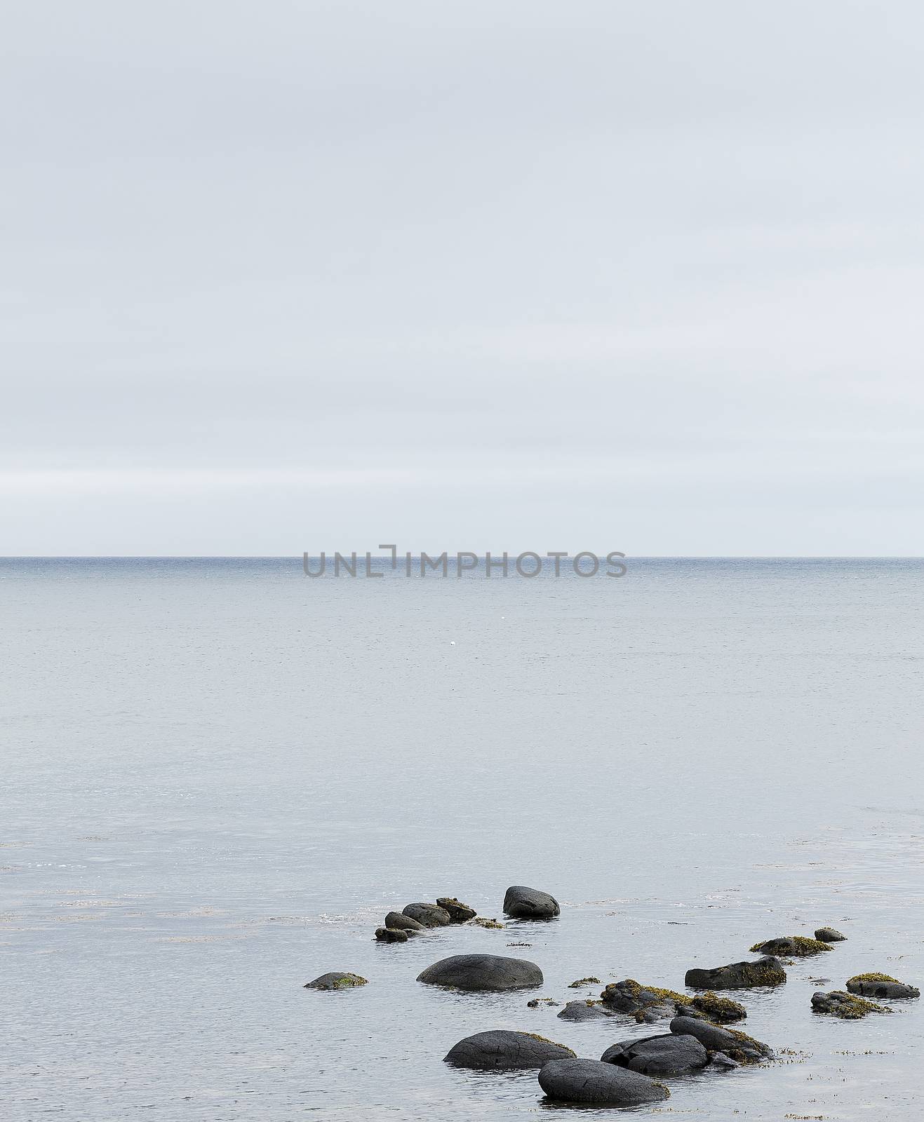 Minimalist image of the Giant's Causeway in Northern Ireland, with rocks in the foreground and the calm sea in the background