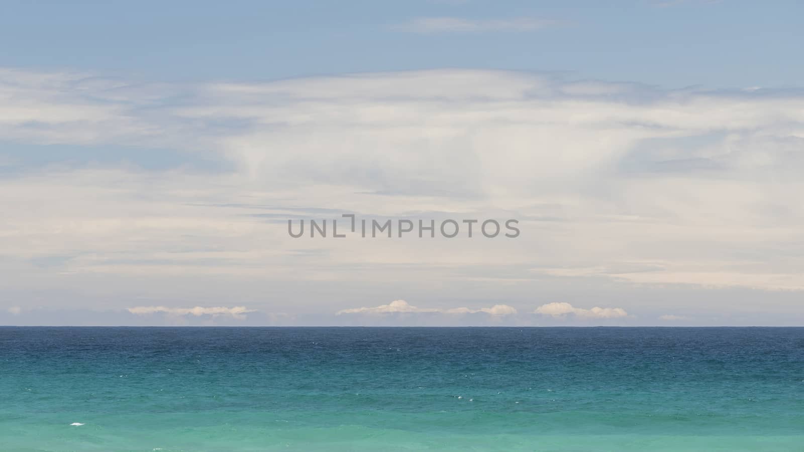 Minimalist seascape with turquoise waters and cloudy sky