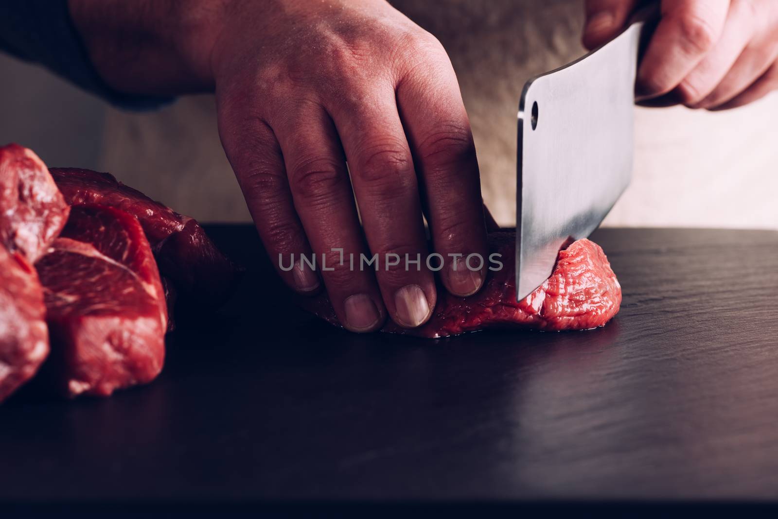 Butcher hands close up: cutting meet