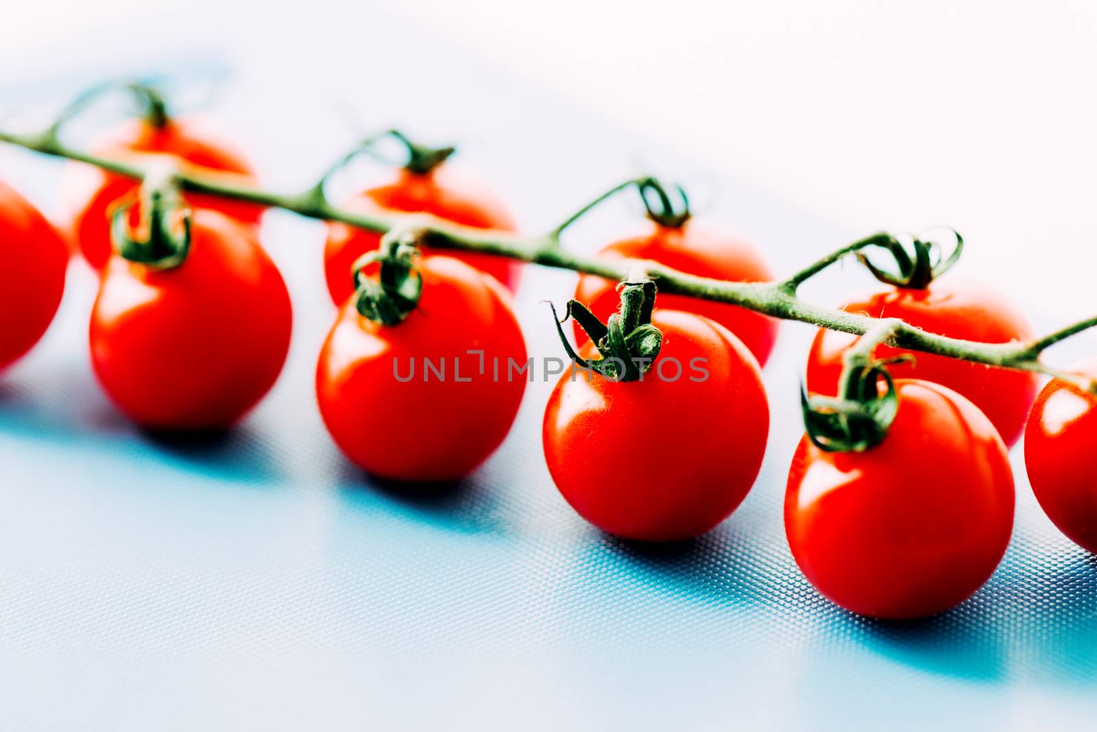 Ripe cherry tomatoes on vine by Nanisimova