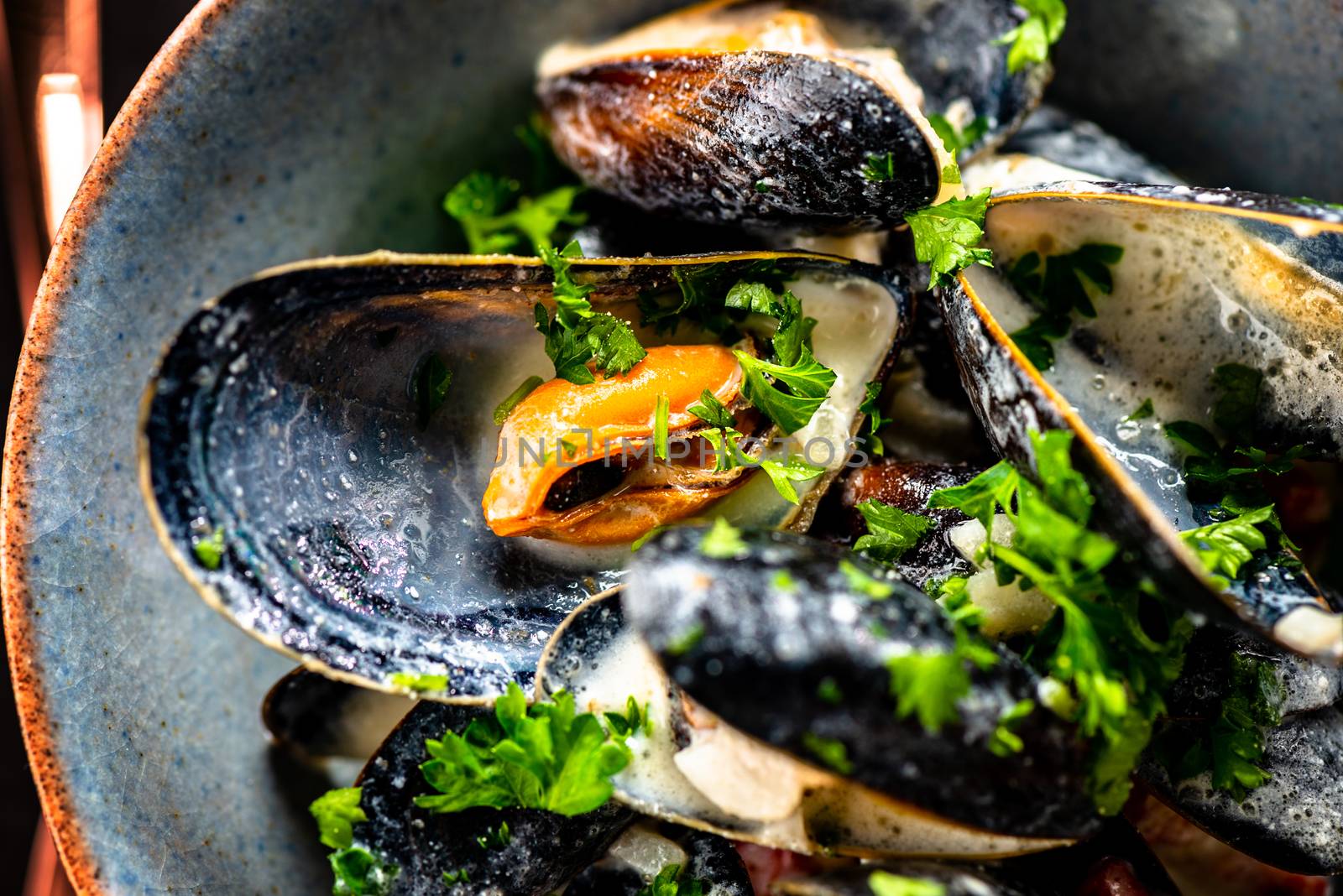 Cooked Blue mussels in clay dish close up