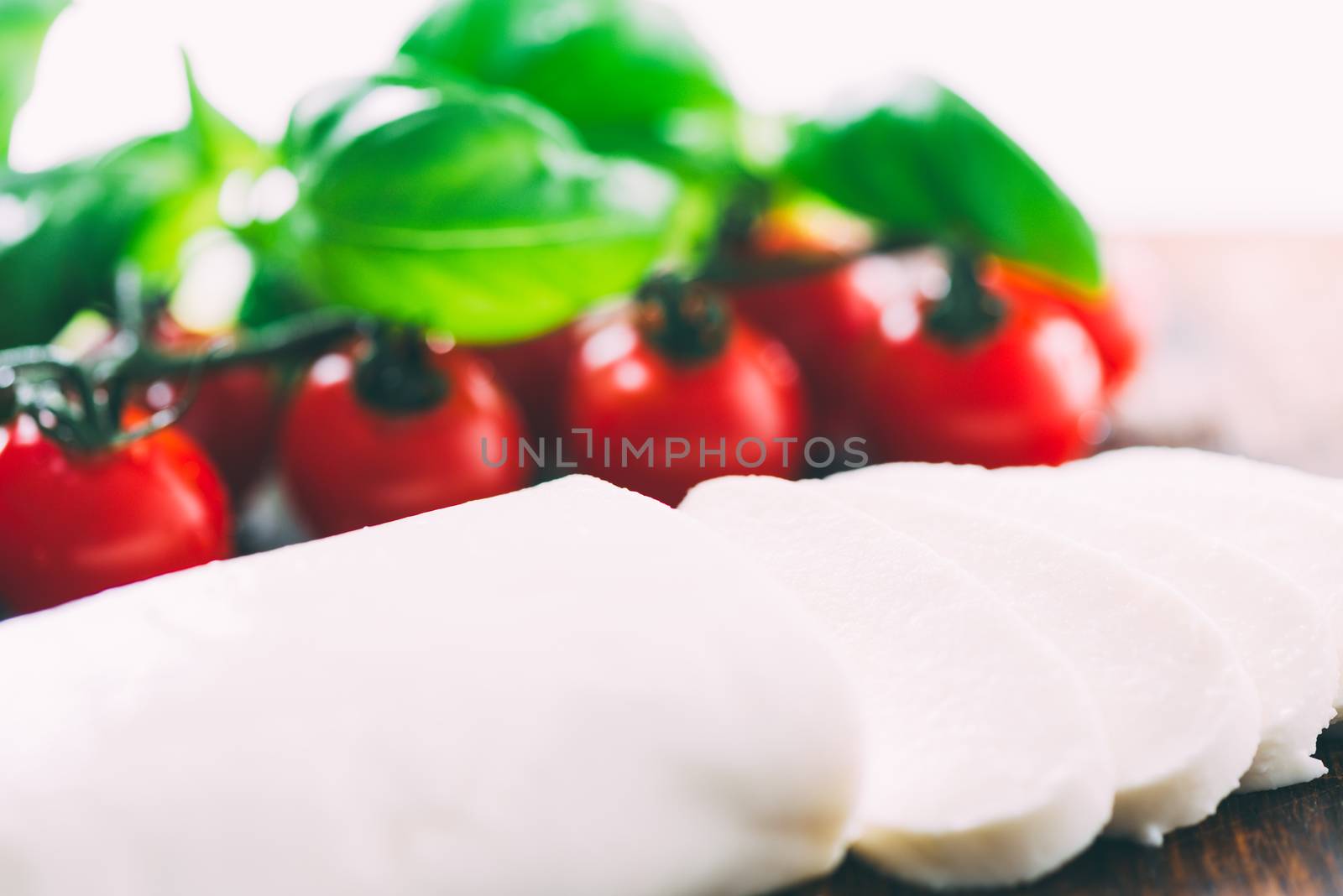 Cutted mozzarella cheese with cherry tomatoes on background