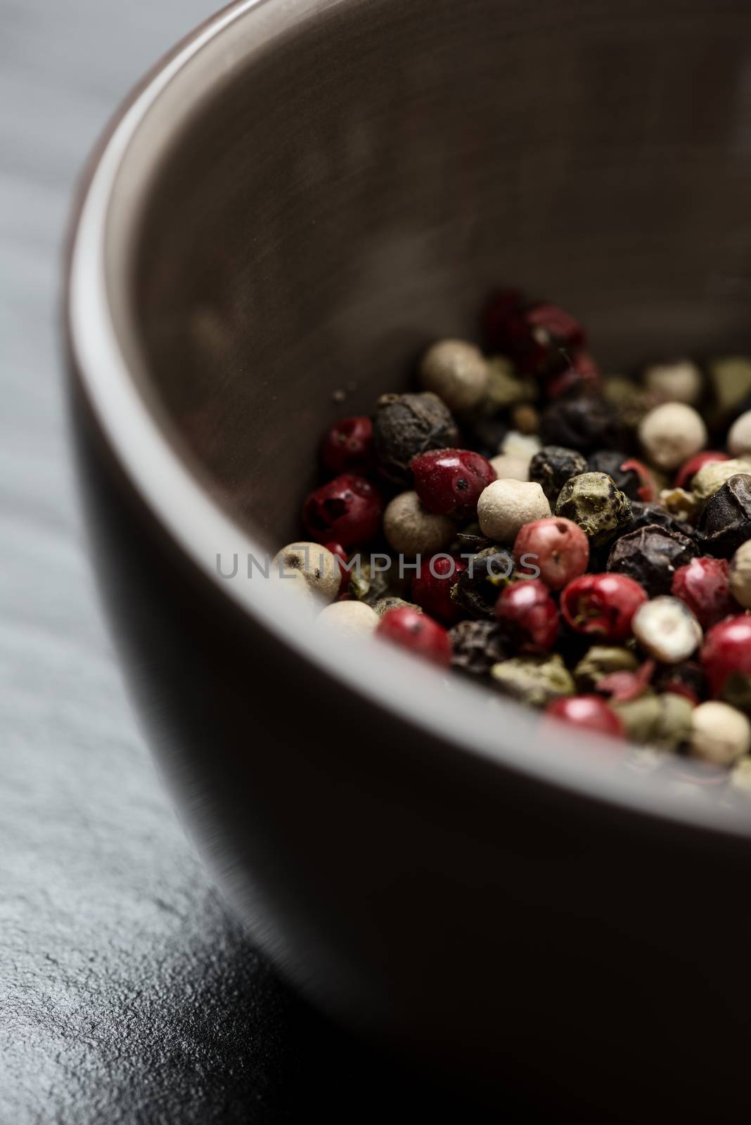 Pepper corn mix in bowl close-up on stone