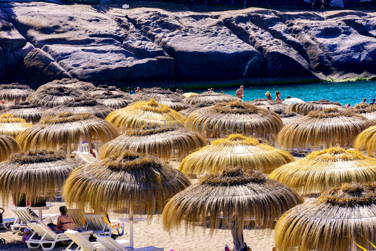 Straw umbrellas on Tenerife beach by Nanisimova