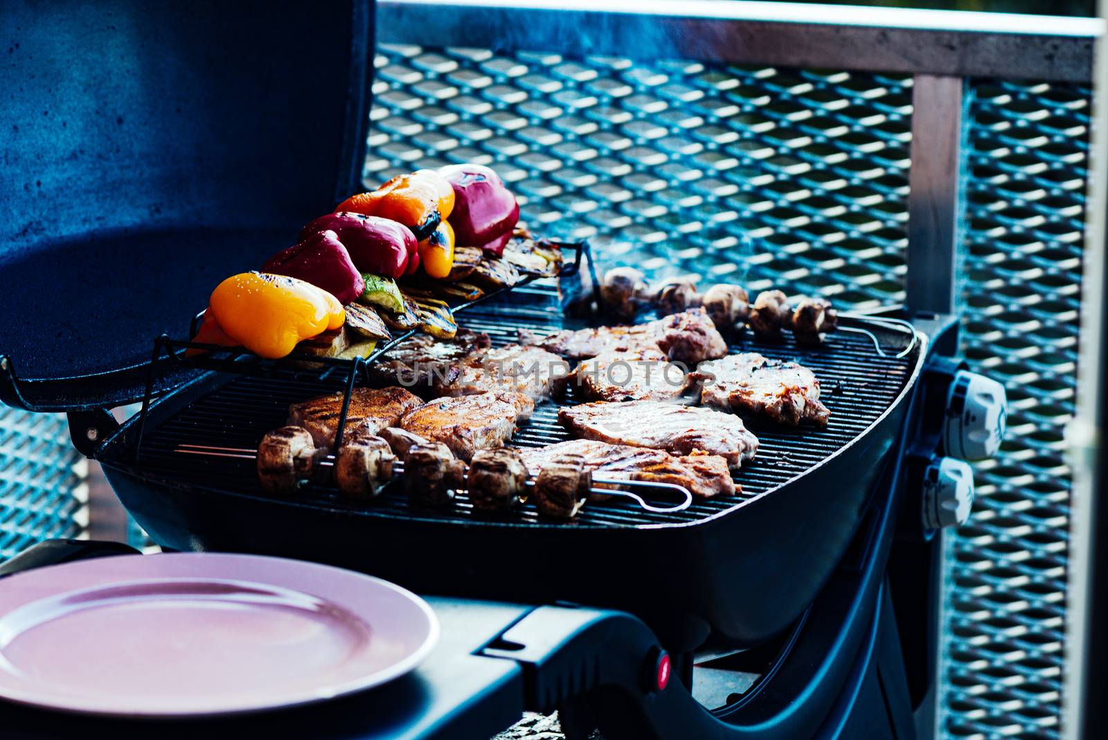 Assorted vegetables and meat cooking on a grill