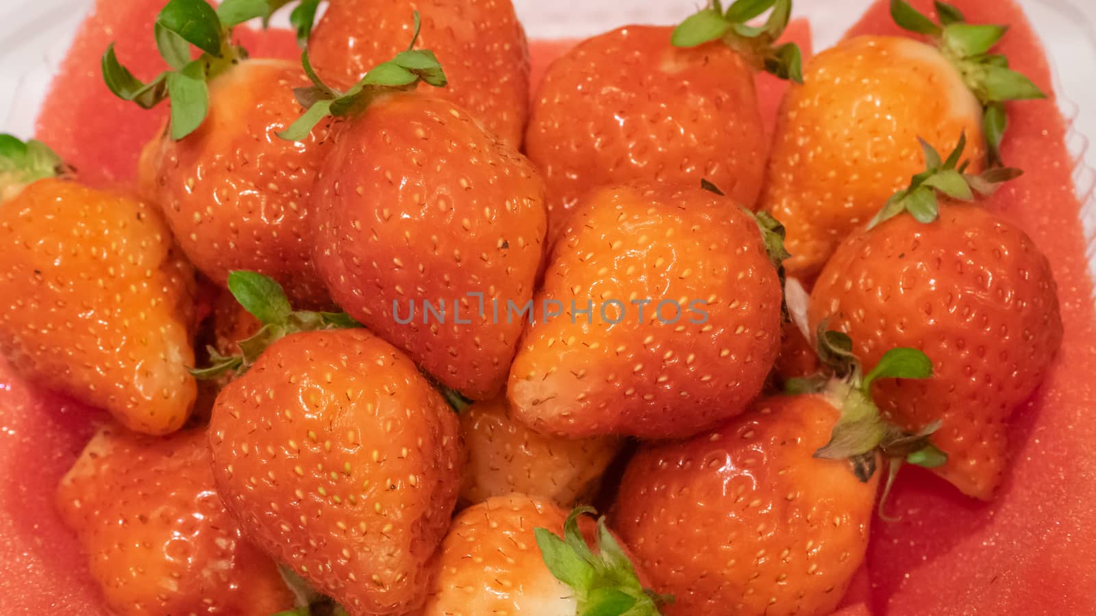 The close up of delicious strawberry fruit on red foam pad background.