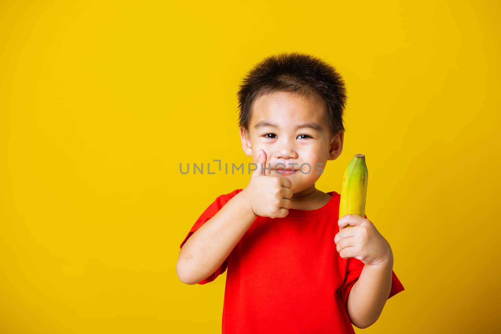 kid cute little boy attractive smile playing holds bananas and s by Sorapop