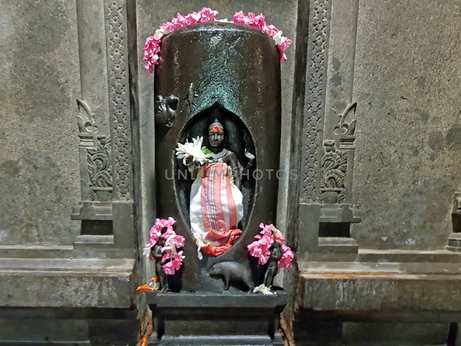 Ancient Durga statue decorated with flowers in the Sri Ramana Ashram in Tiruvanamalai India