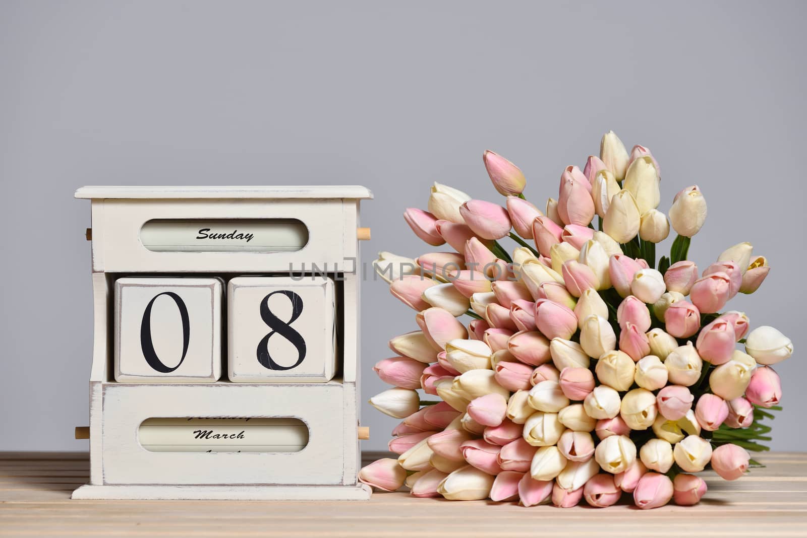 Retro calendar with the date of March 8 and tulips, International Women's Day and free text space on a gray wall background.